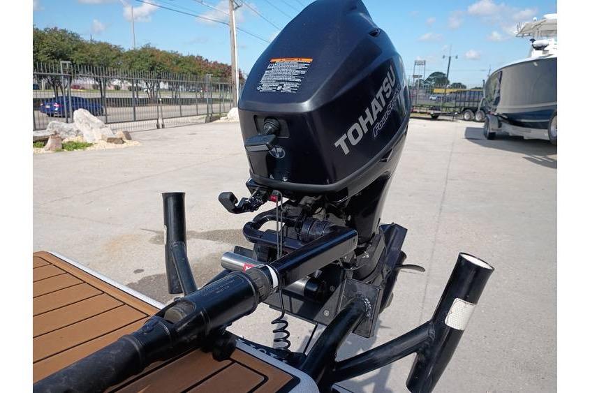 Tohatsu outboard motor on a 2013 Pelican Ambush boat, parked outdoors.