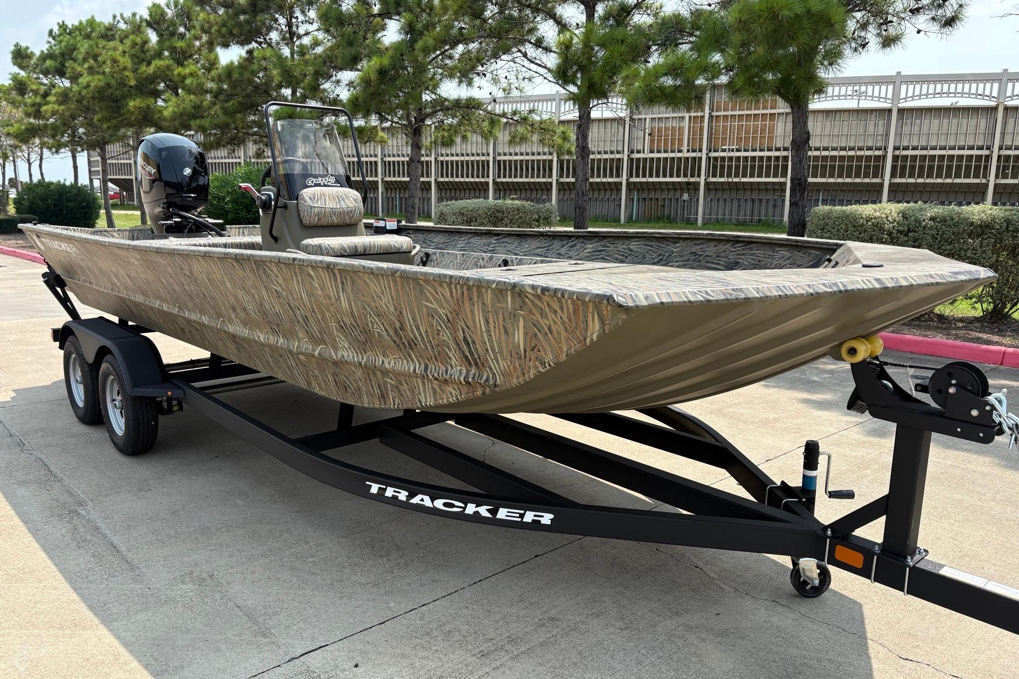 2026 Tracker Grizzly 2072 CC boat on trailer, camo design, parked outdoors.