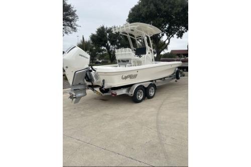 2026 Mako 24 APEX boat on trailer, parked outdoors.