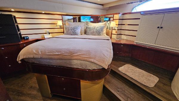 Luxurious bedroom interior of 2005 Neptunus 56 Flybridge yacht with elegant wood finishes.