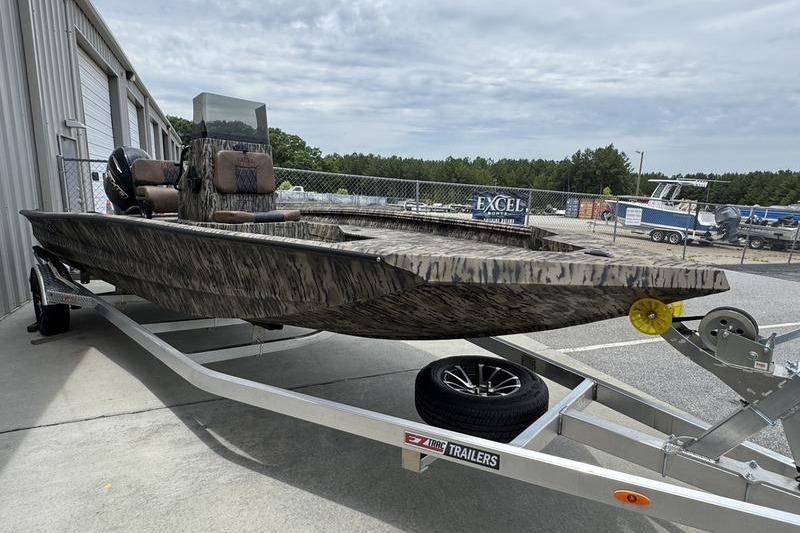 2027 Excel 230 Bay Pro Elite boat on trailer, parked outdoors near a building.