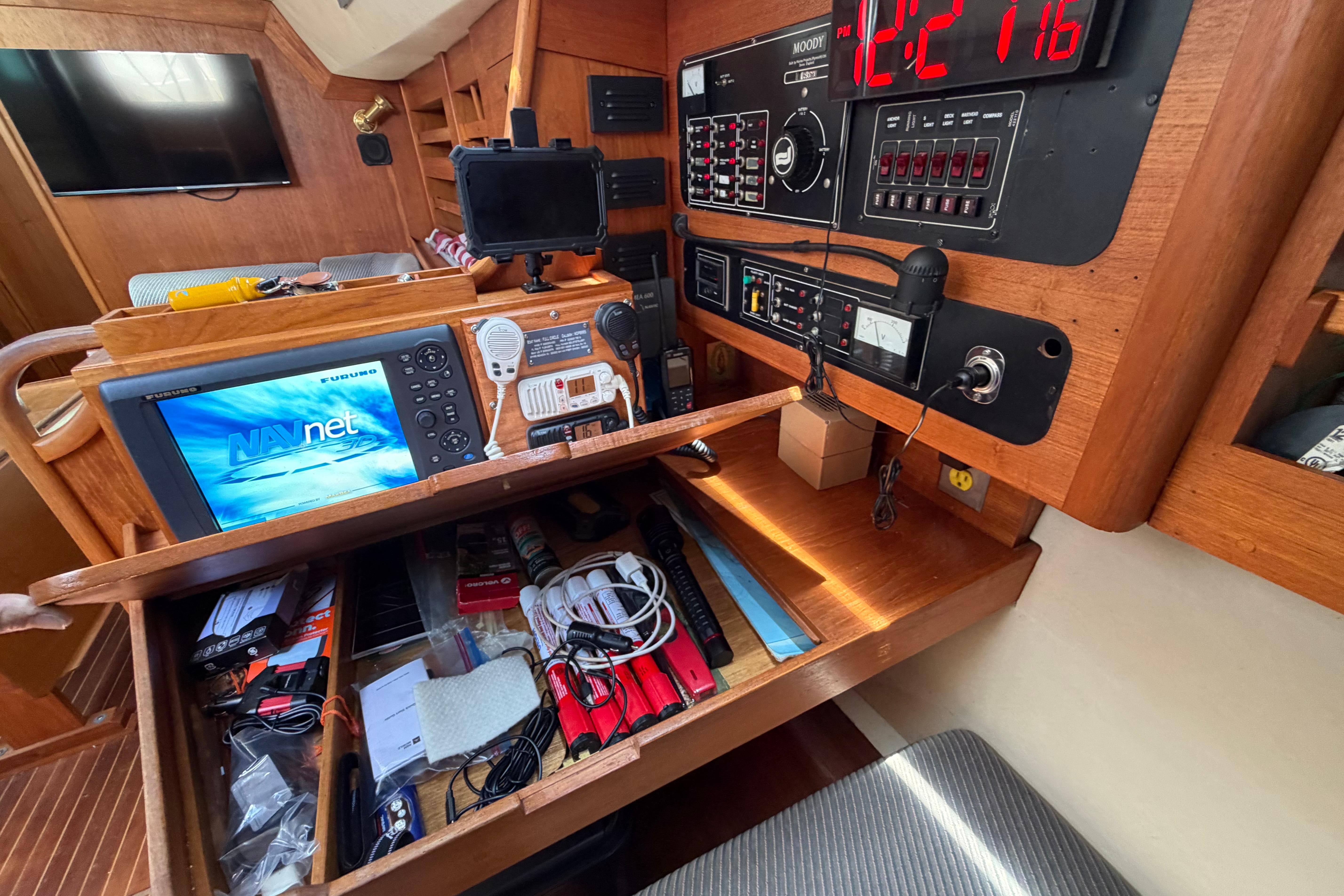 Navigation station on a 1987 Moody 376 yacht with electronic equipment and storage.