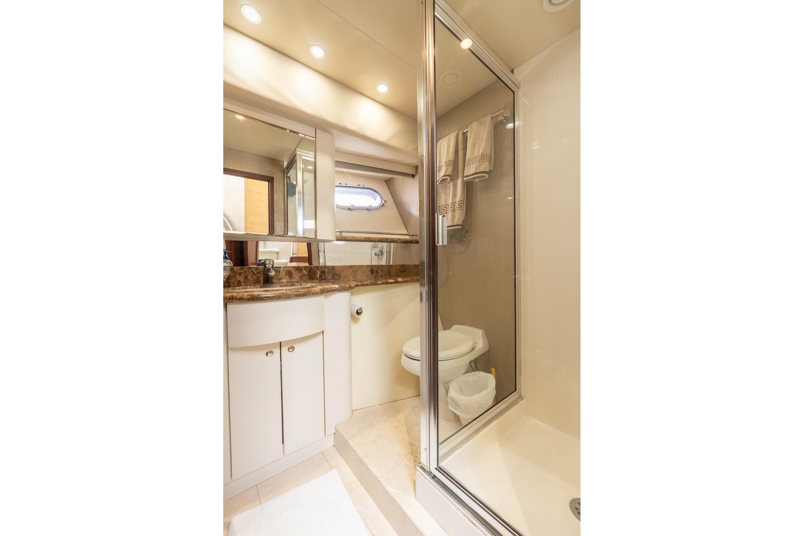 Luxurious bathroom in 2009 Pacific Mariner 65 Motoryacht with marble countertop and glass shower.