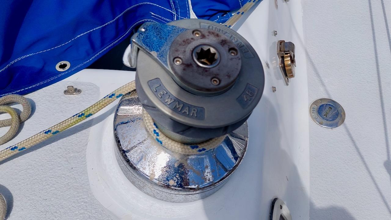 Winch on 1981 Morgan Out Island 41 sailboat deck with blue sail cover.