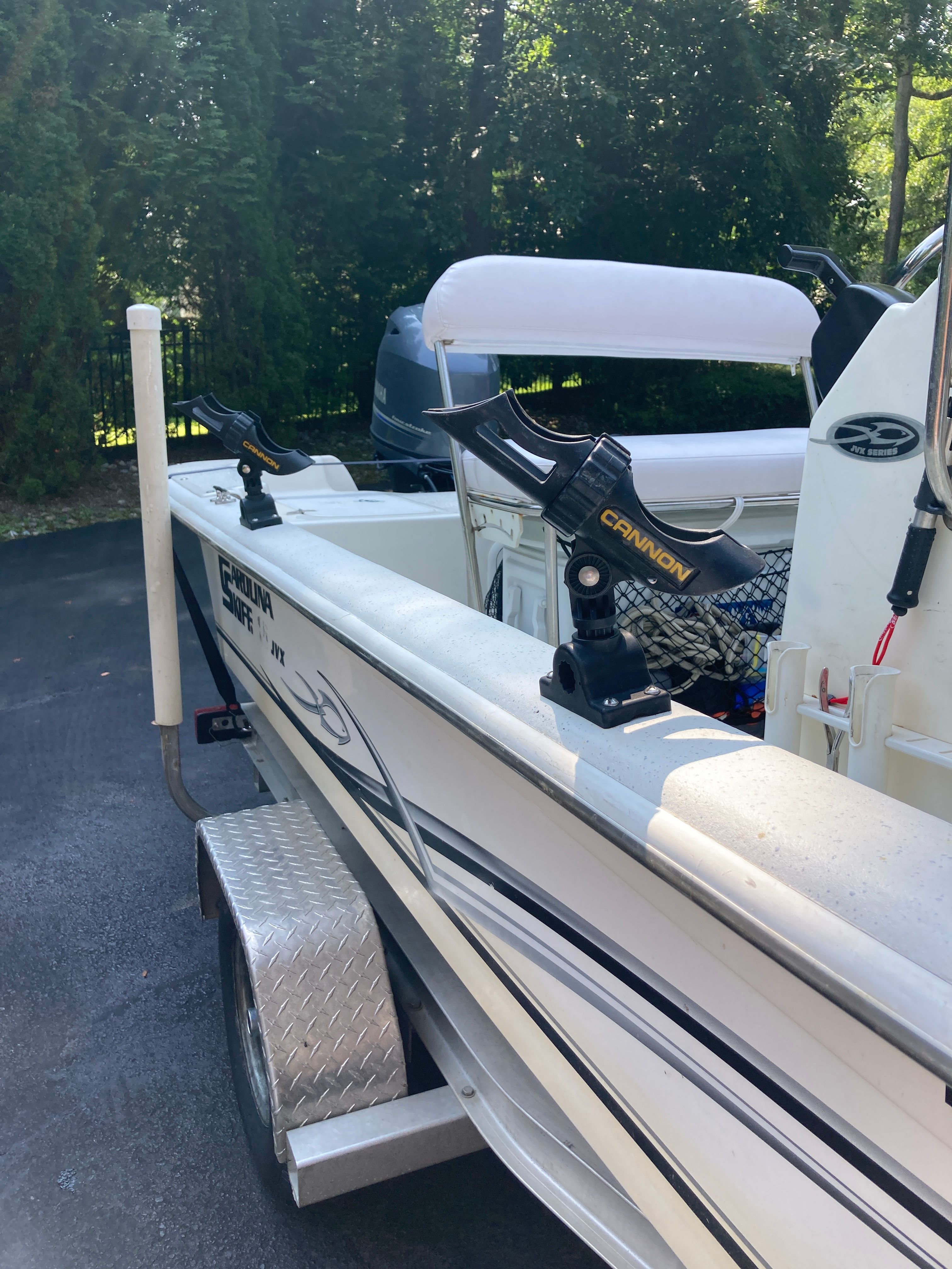 A 2012 Carolina Skiff JVX16CC on a trailer, equipped with fishing rod holders.