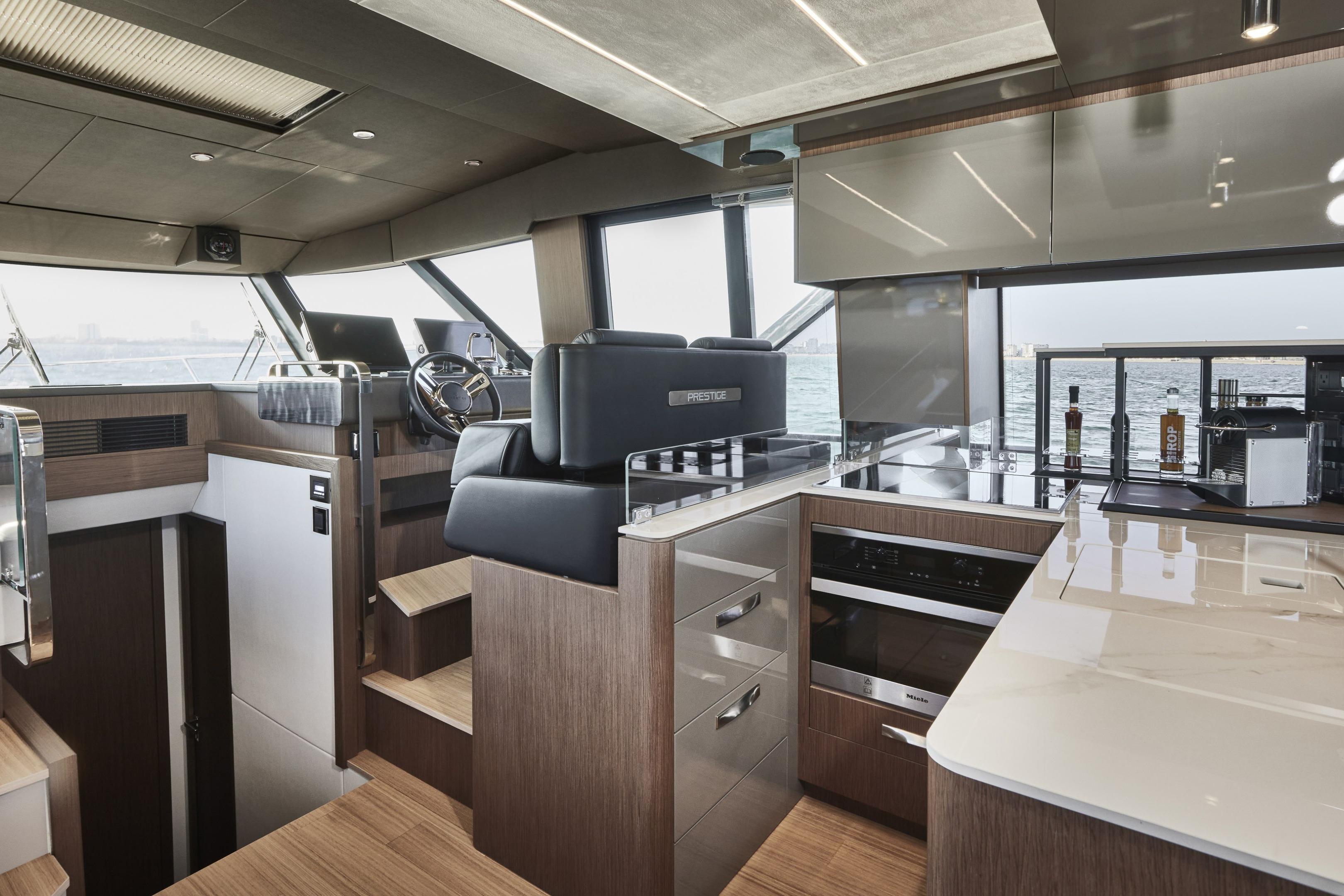 Luxurious interior of 2026 Prestige X60 yacht with modern kitchen and helm station.
