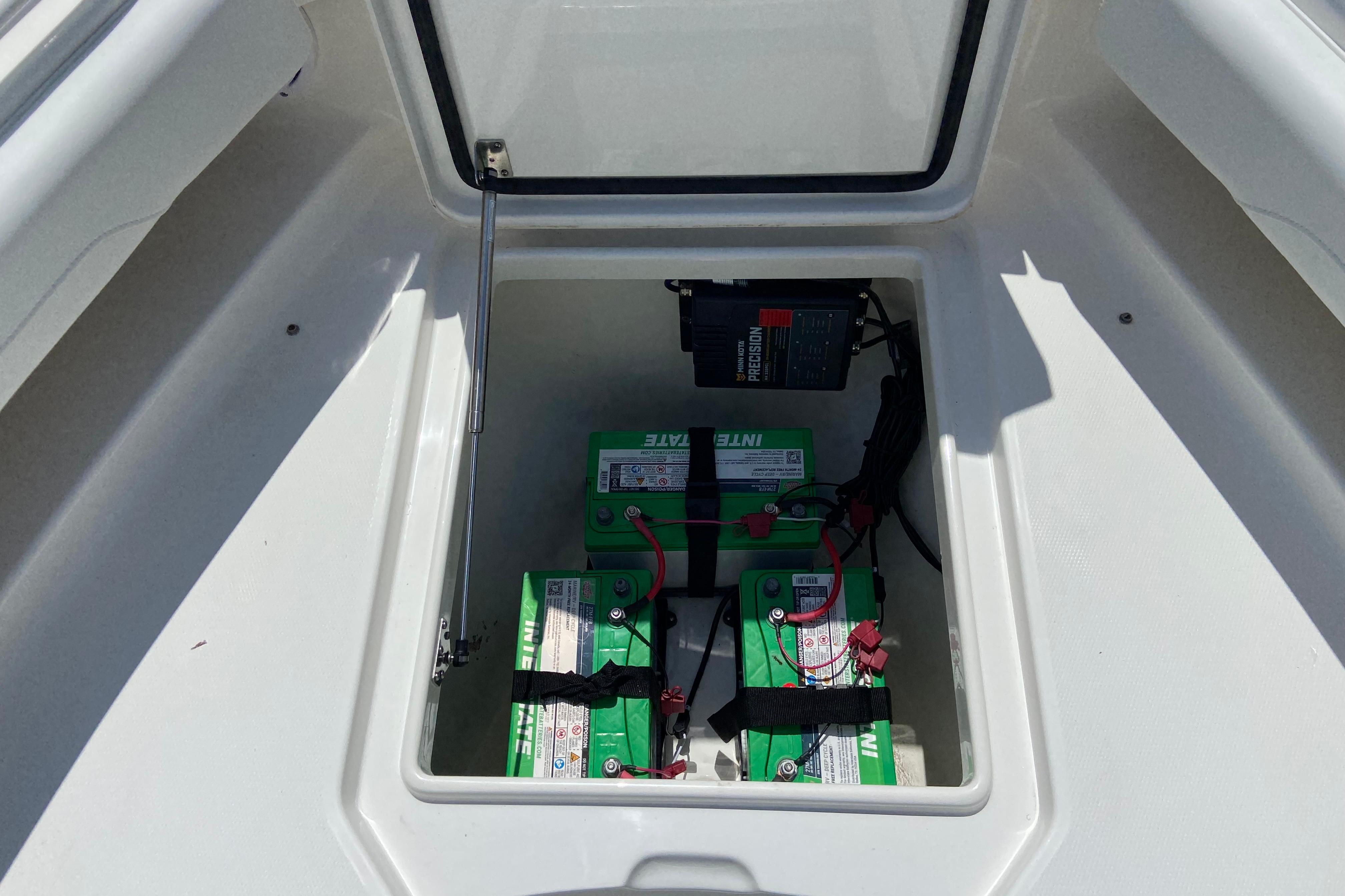 Battery compartment of a 2021 Regulator 28 boat, featuring green marine batteries.