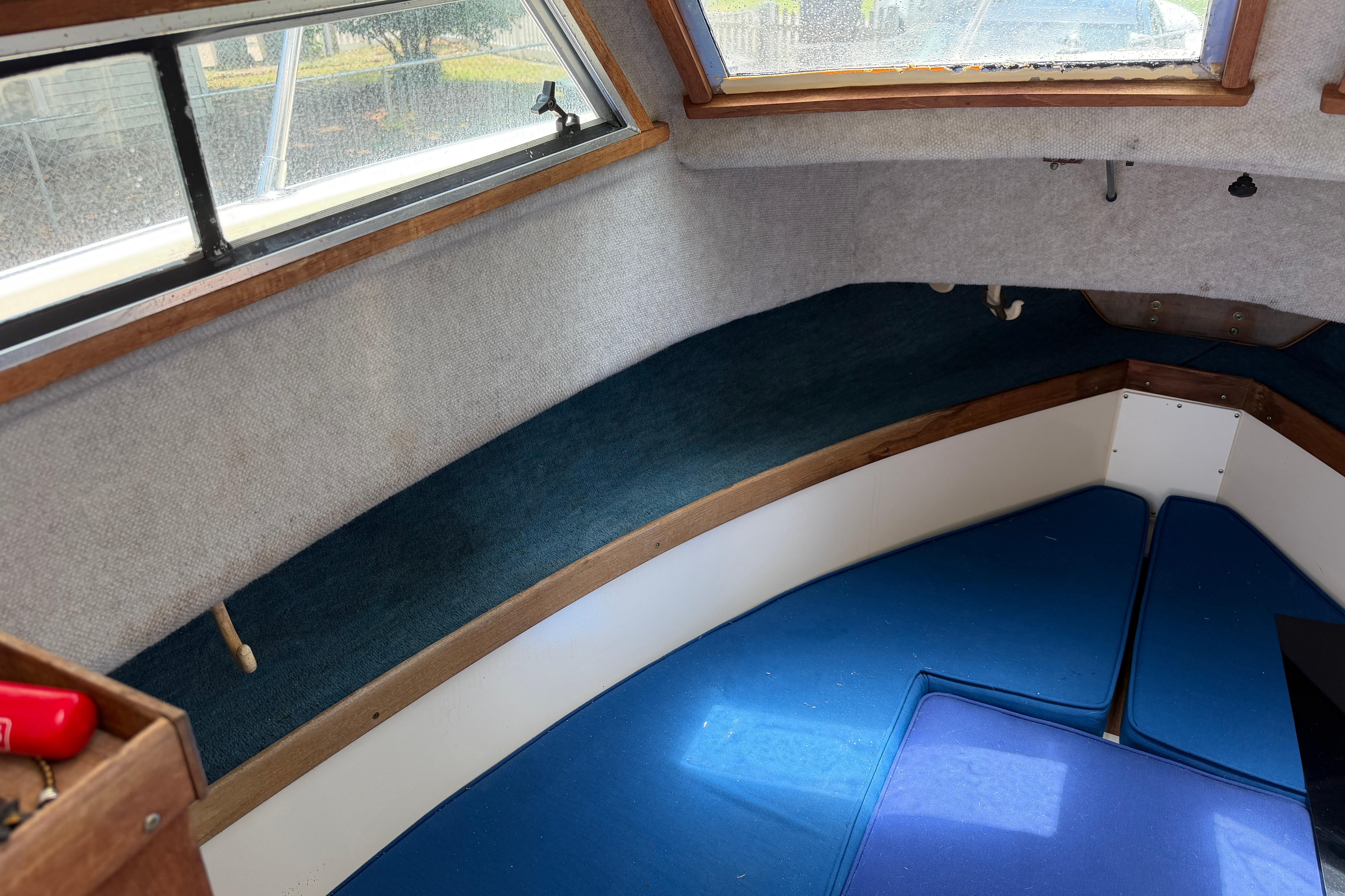Interior cabin of a 1987 Grady-White Seafarer 226 boat with blue cushions.