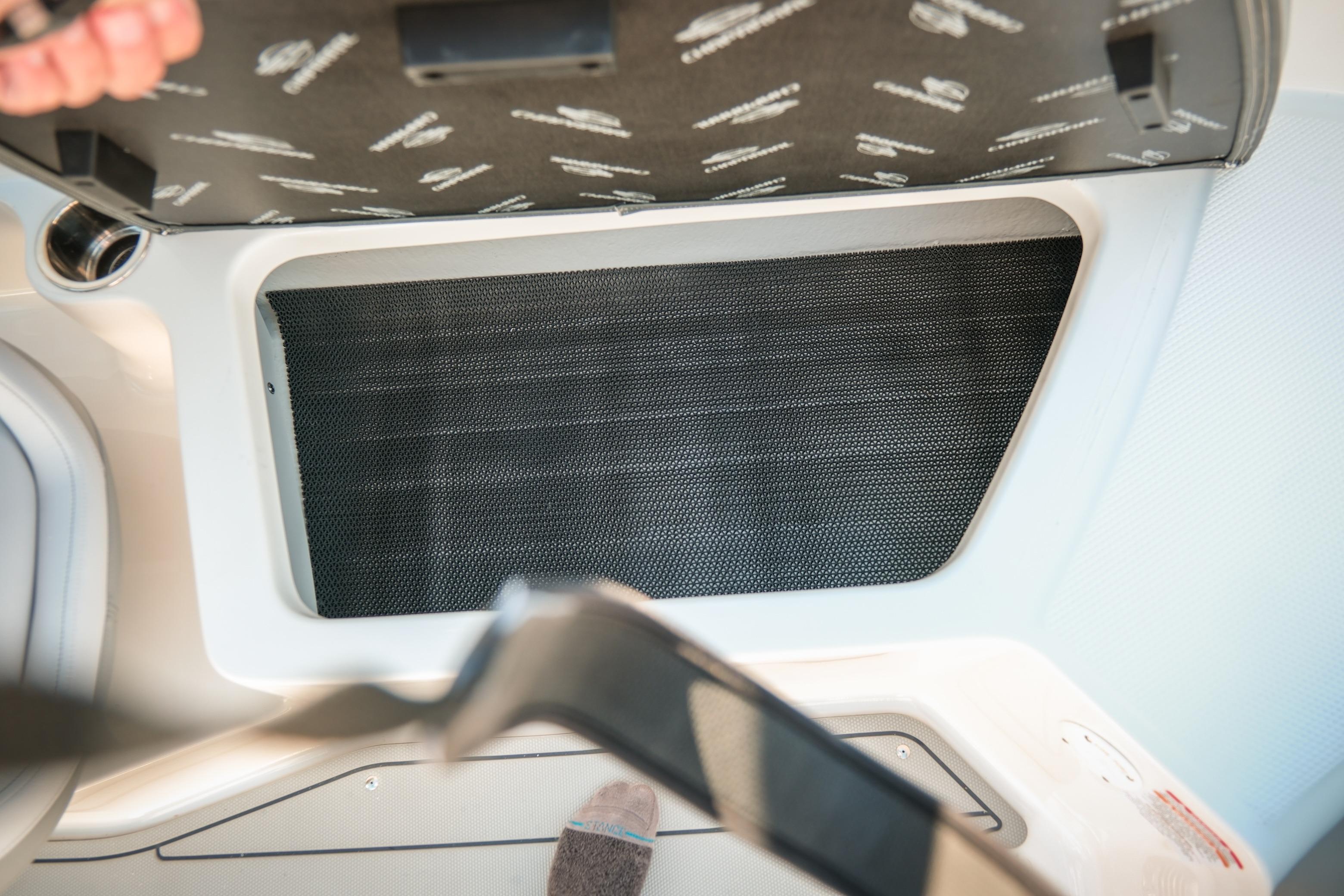 2026 Chaparral 23 SSi boat storage compartment with open lid, showcasing interior details.