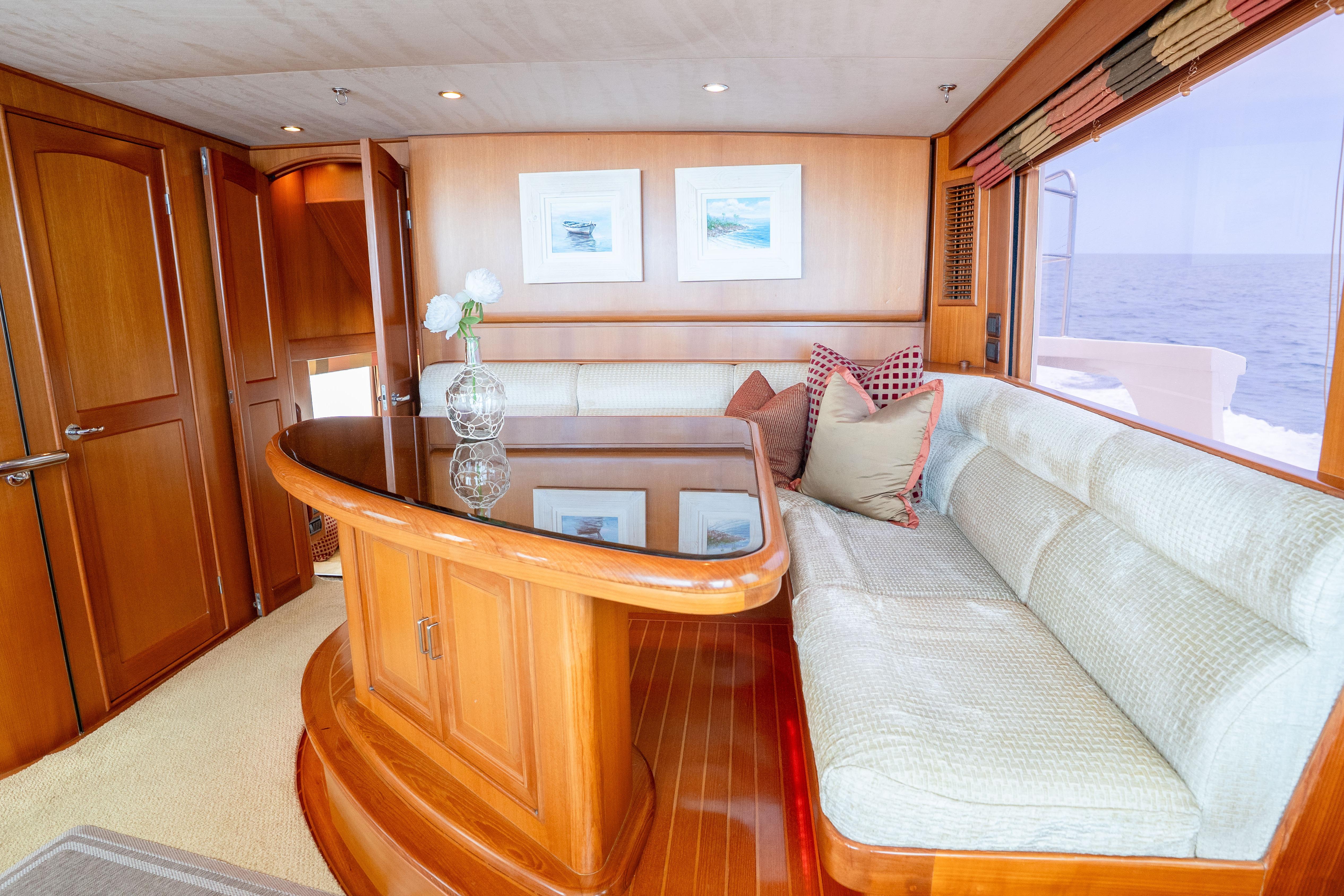 Luxurious interior of 2006 Fleming 75 yacht with elegant wood finishes and plush seating.