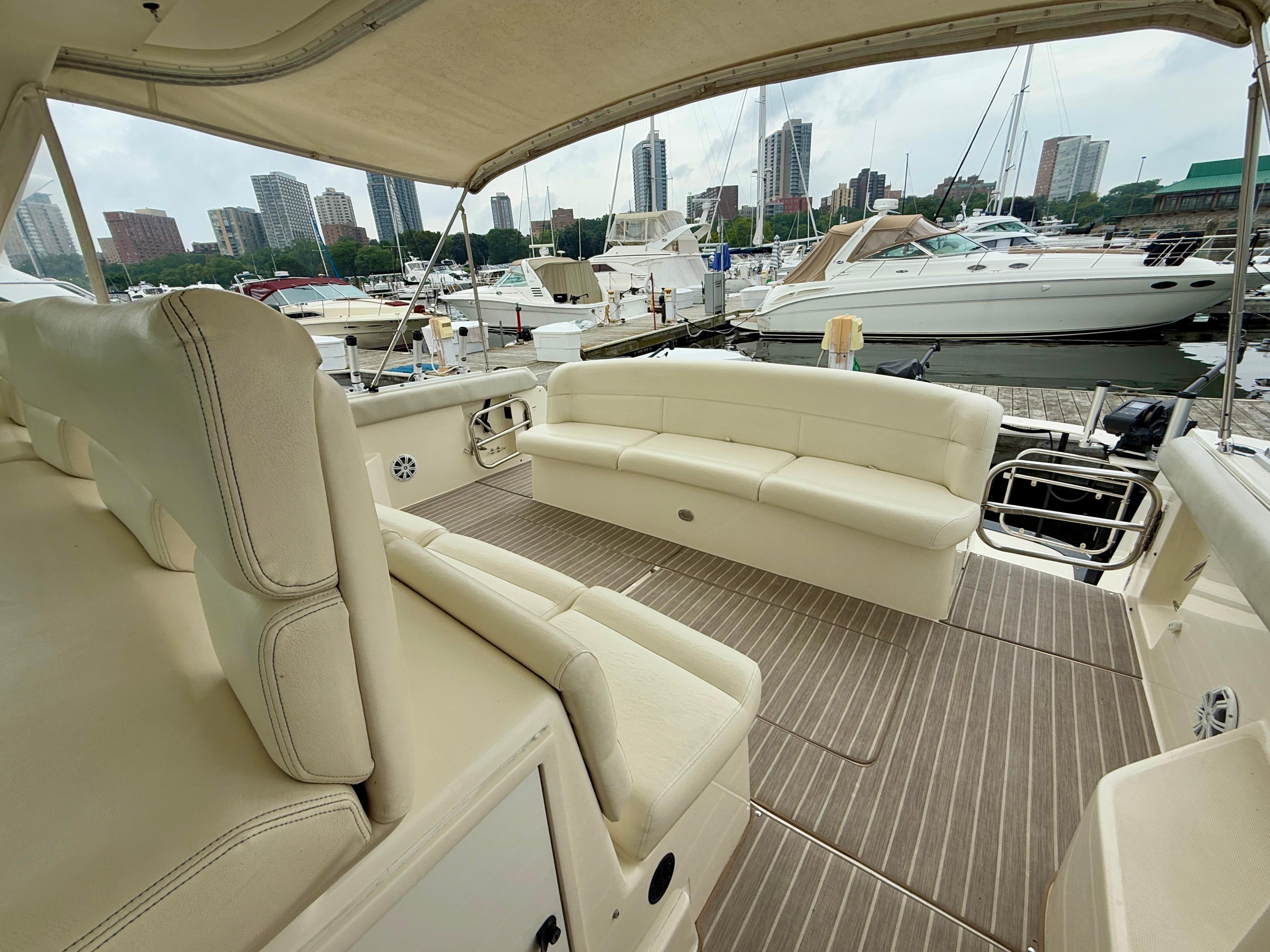2004 Tiara Yachts 4000 Express interior with beige seating, docked in a marina.