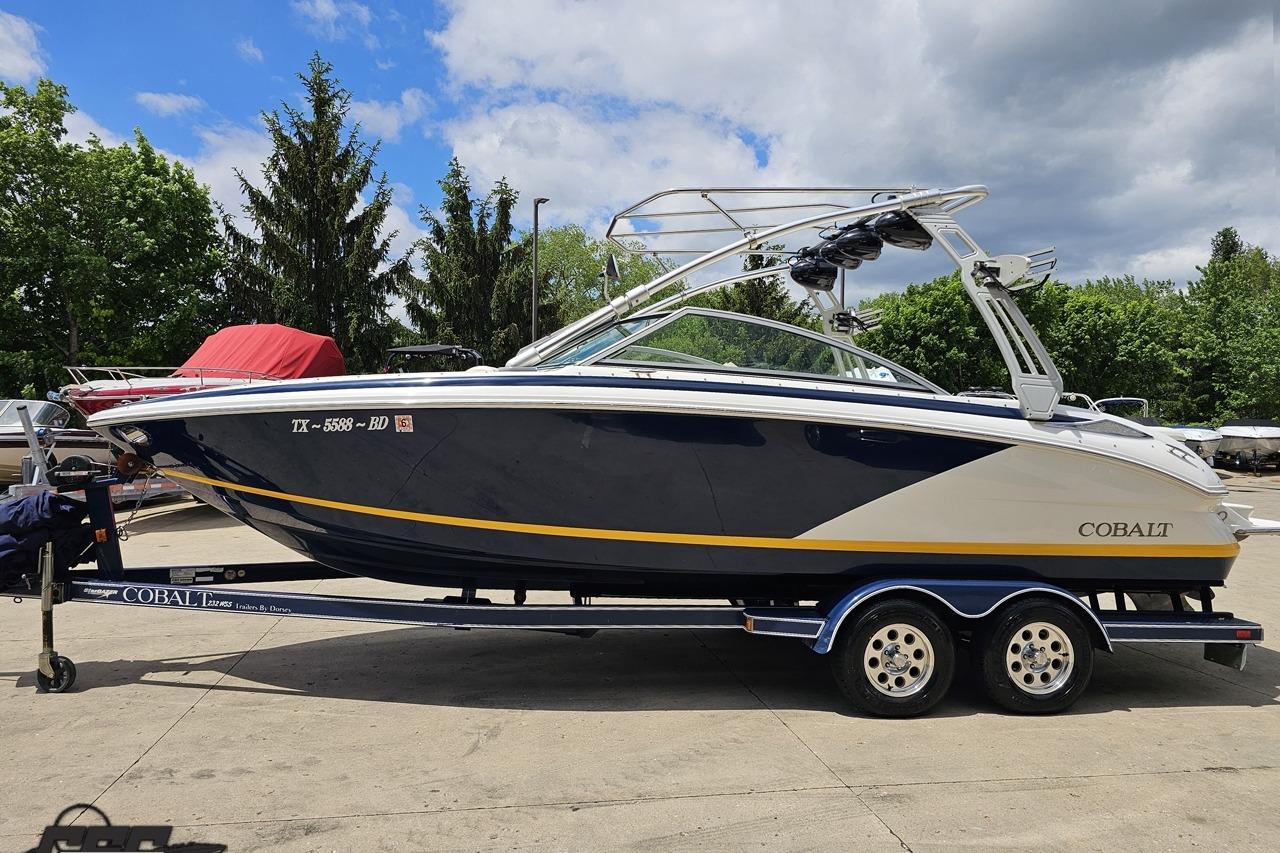 2010 Cobalt 232 WSS boat on trailer, parked outdoors under a partly cloudy sky.