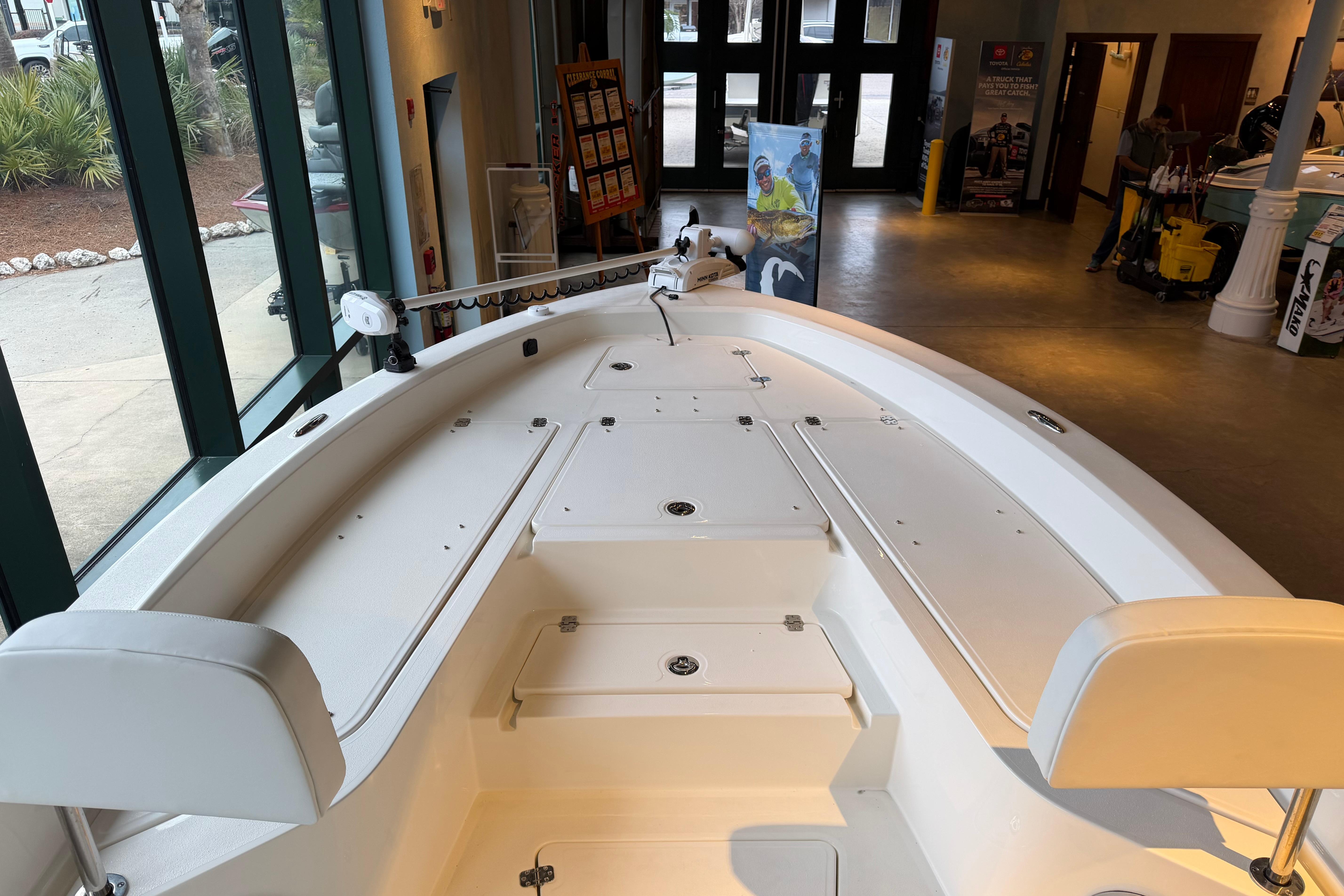 2026 Mako 24 APEX boat interior in showroom, featuring spacious deck and seating.
