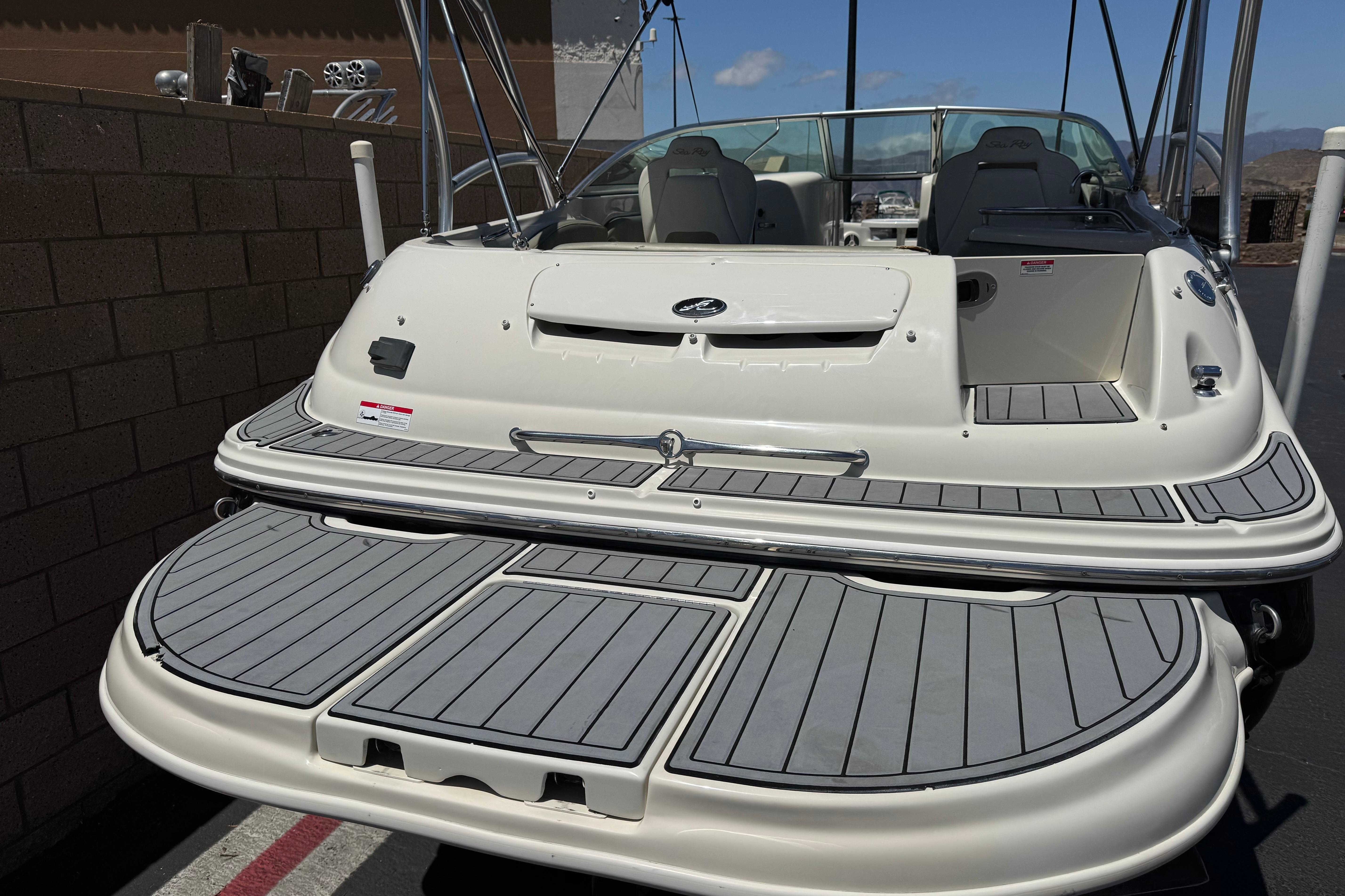2007 Sea Ray 240 Sundeck boat with spacious deck and seating, docked outdoors.