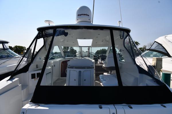 2010 Cruisers Yachts 390 Sports Coupe, rear view, docked, with clear canopy and modern design.