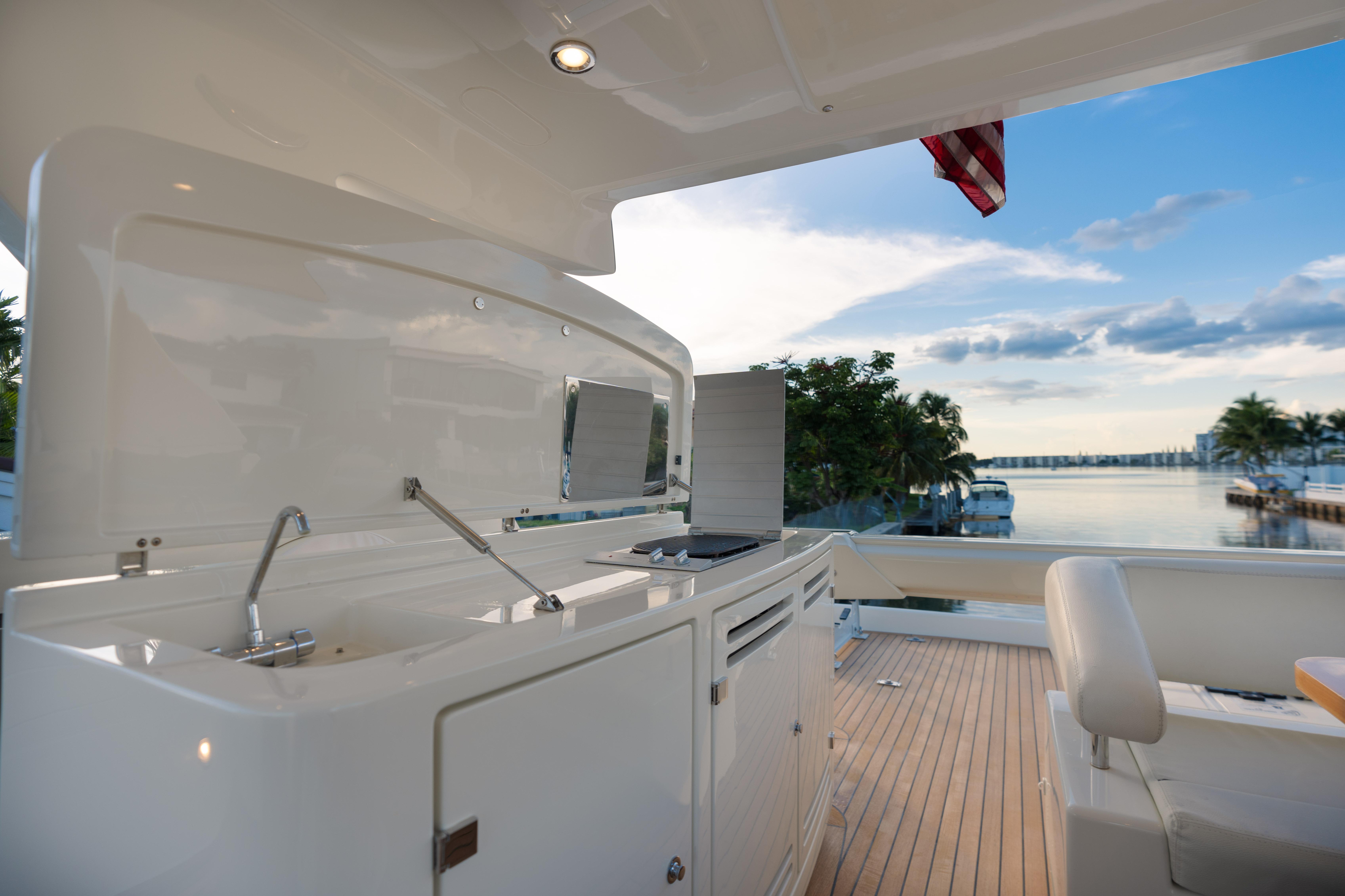 Outdoor kitchen on a 2012 Riva 75 Venere yacht with scenic waterfront view.