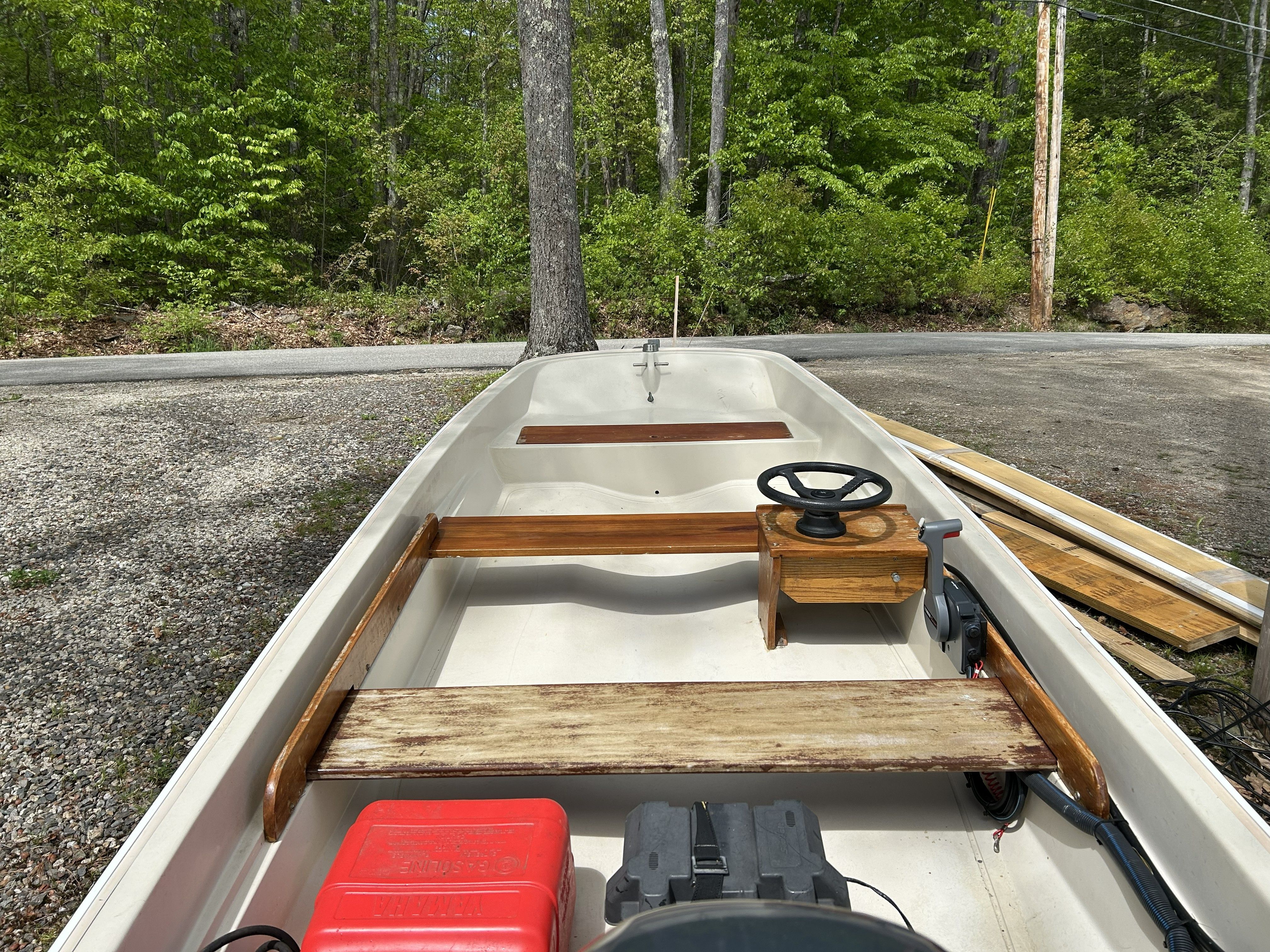1975 Boston Whaler 13 ft. boat with wooden details outdoors.