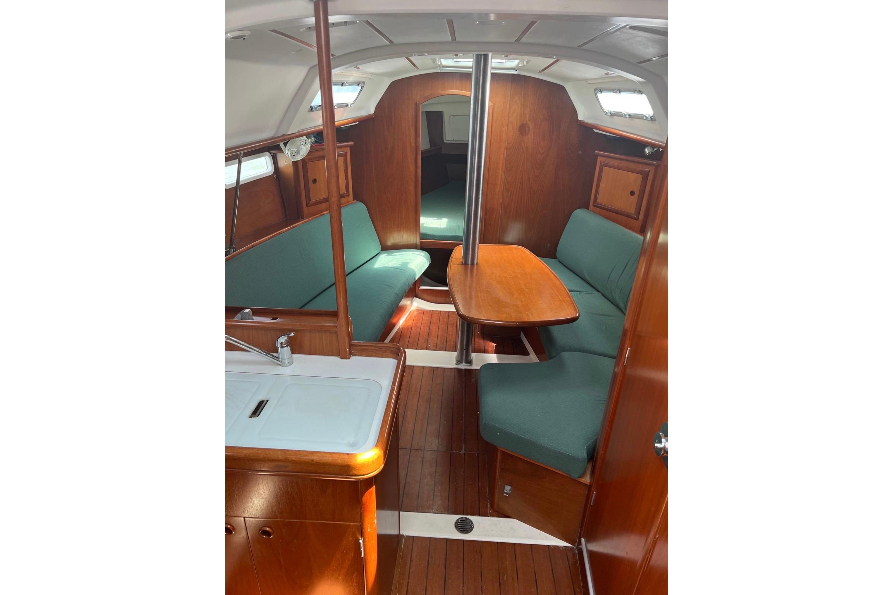Interior of 2001 Beneteau 331 sailboat with wood finish and green seating.