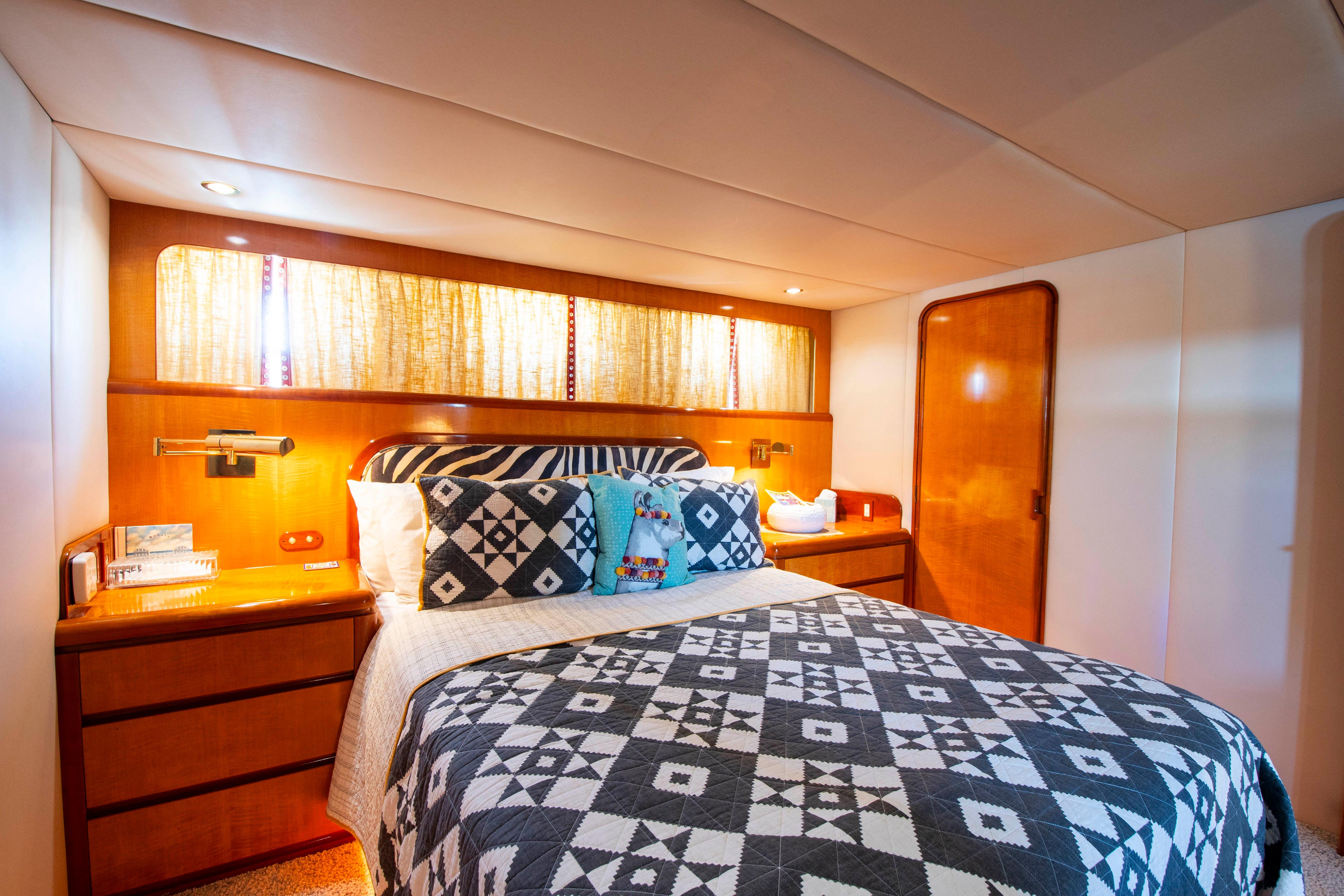 Luxurious 1988 Knight & Carver motoryacht bedroom with patterned bedding and warm wood accents.