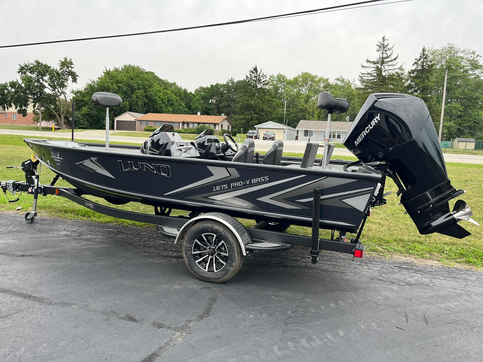 2026 Lund 1875 Pro-V Bass XS boat on trailer, featuring sleek design and Mercury outboard motor.