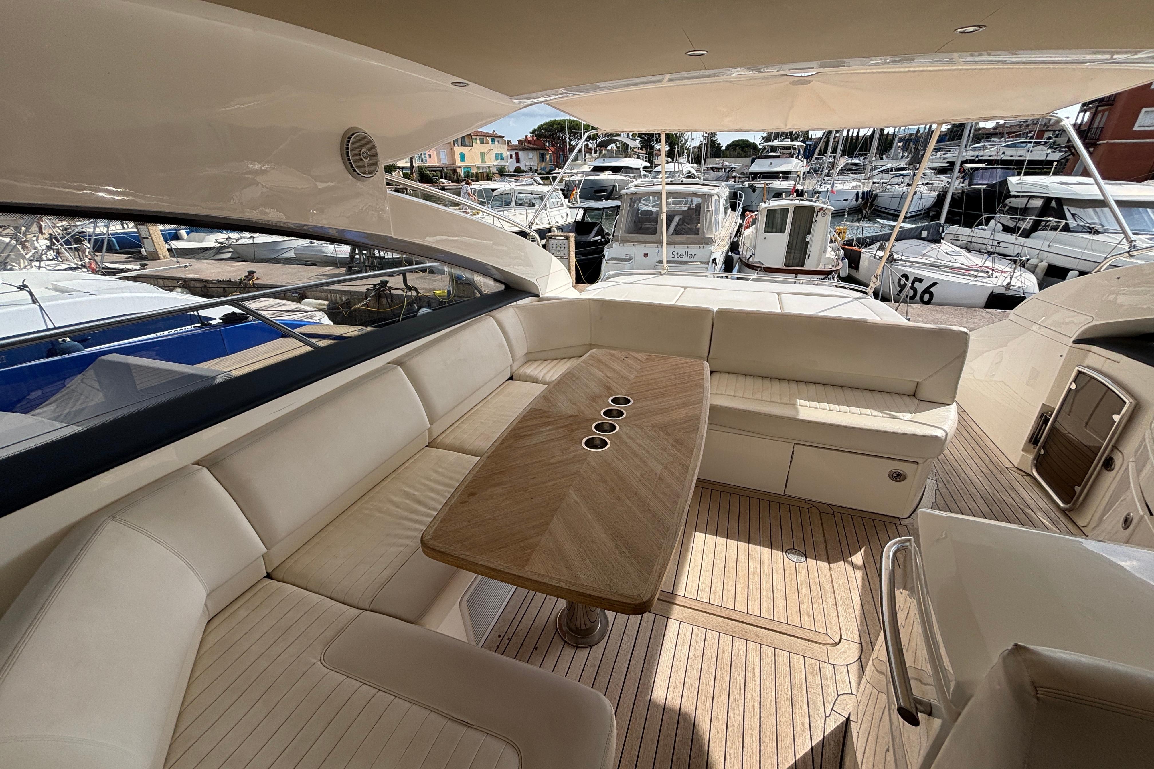 Luxurious 2008 Princess V53 yacht interior with elegant seating and wooden table in a marina setting.