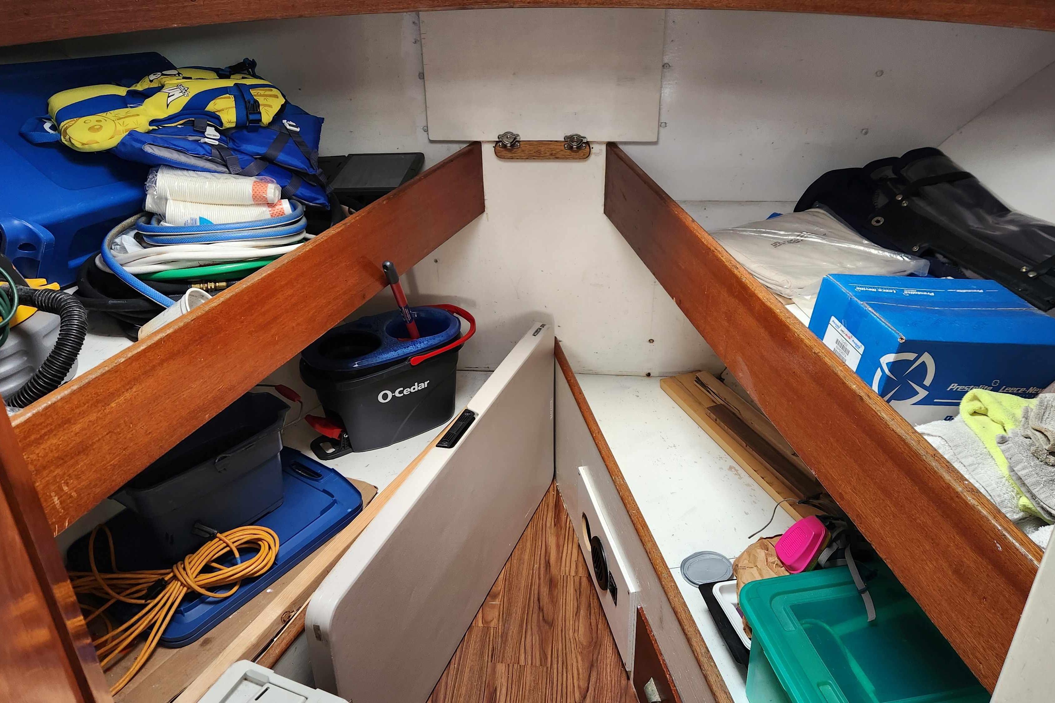 Interior storage of a 1964 Grandy Tour Boat with various supplies and equipment.