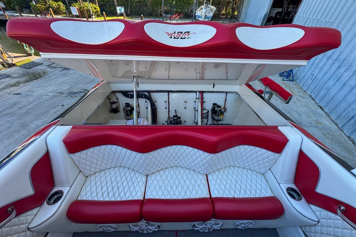 Red and white seating on 2022 Velocity 290sc boat, open engine compartment.