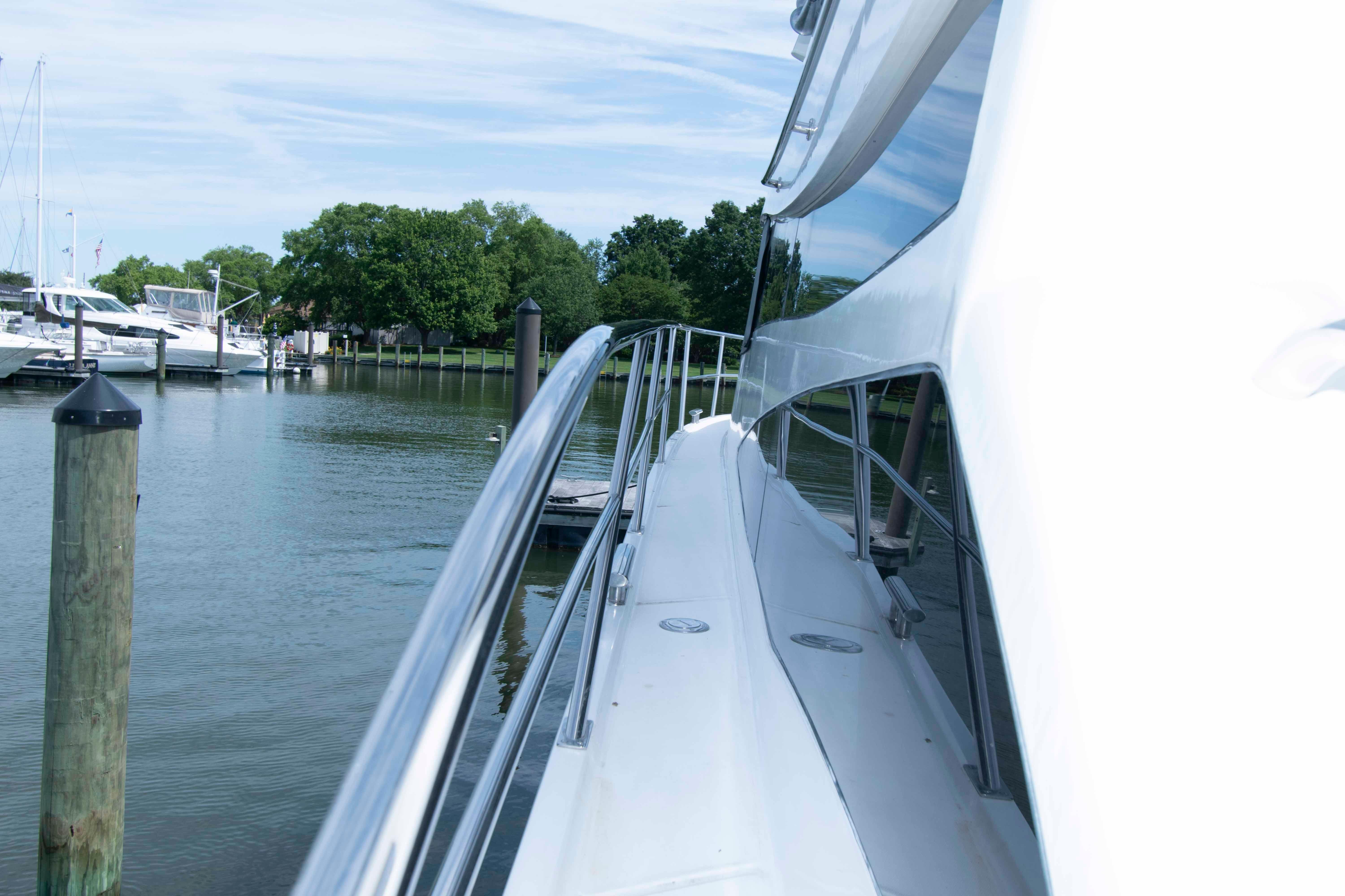 2003 Neptunus 56 Flybridge yacht docked in a serene marina setting.