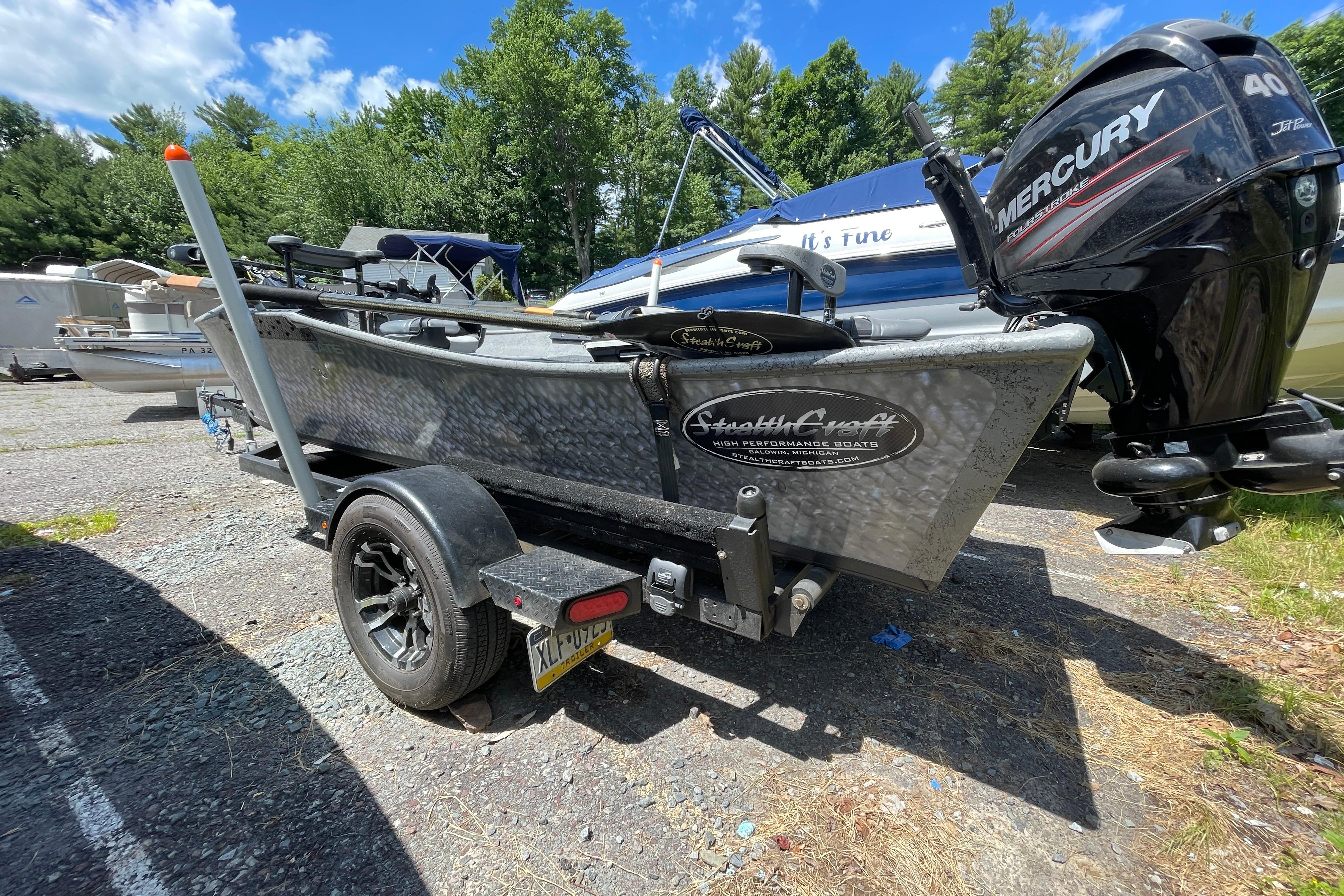 2018 StealthCraft 16 Power Drifter boat with Mercury engine on trailer, parked outdoors.