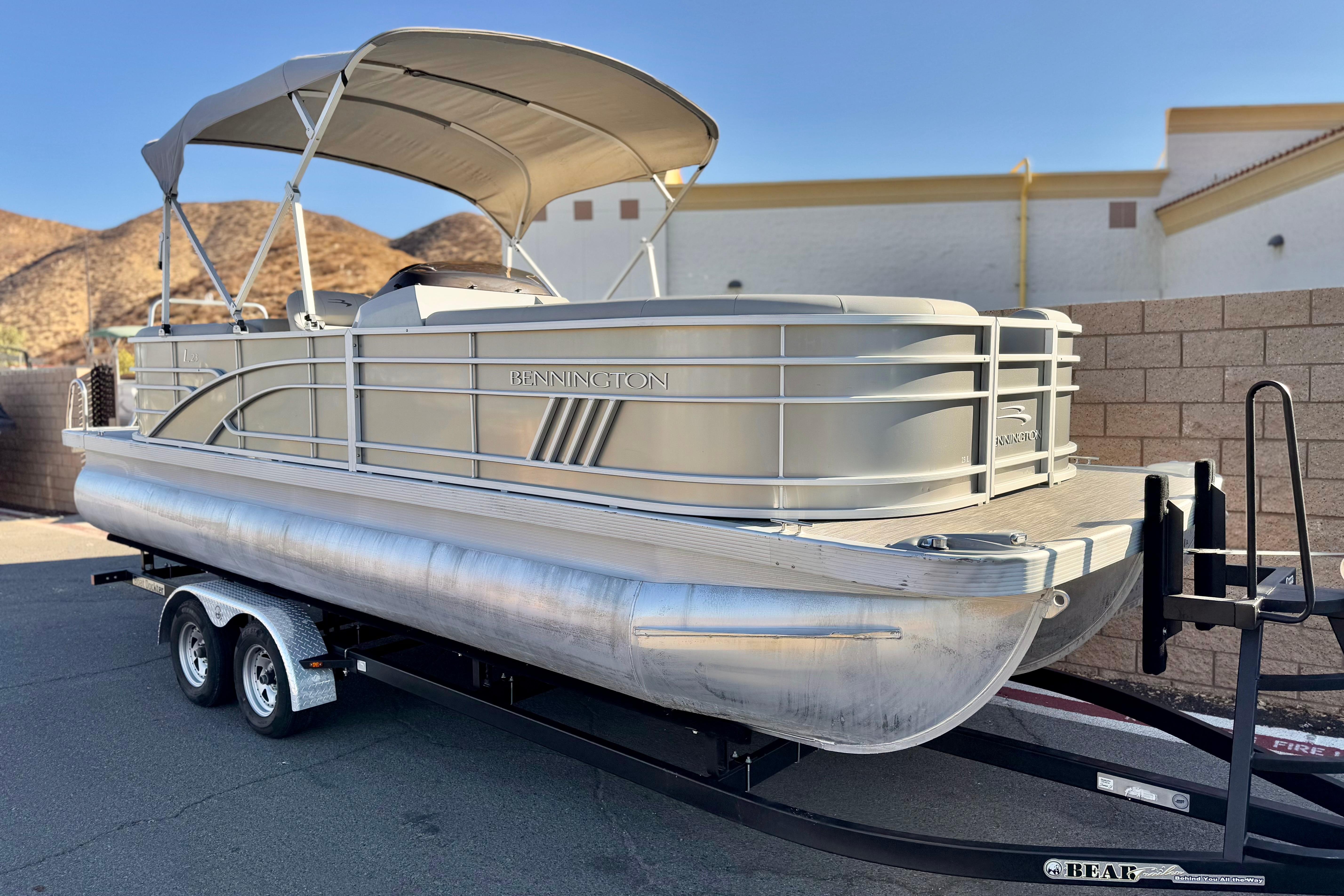 2021 Bennington 23LSR pontoon boat on trailer, parked outdoors with hills in background.