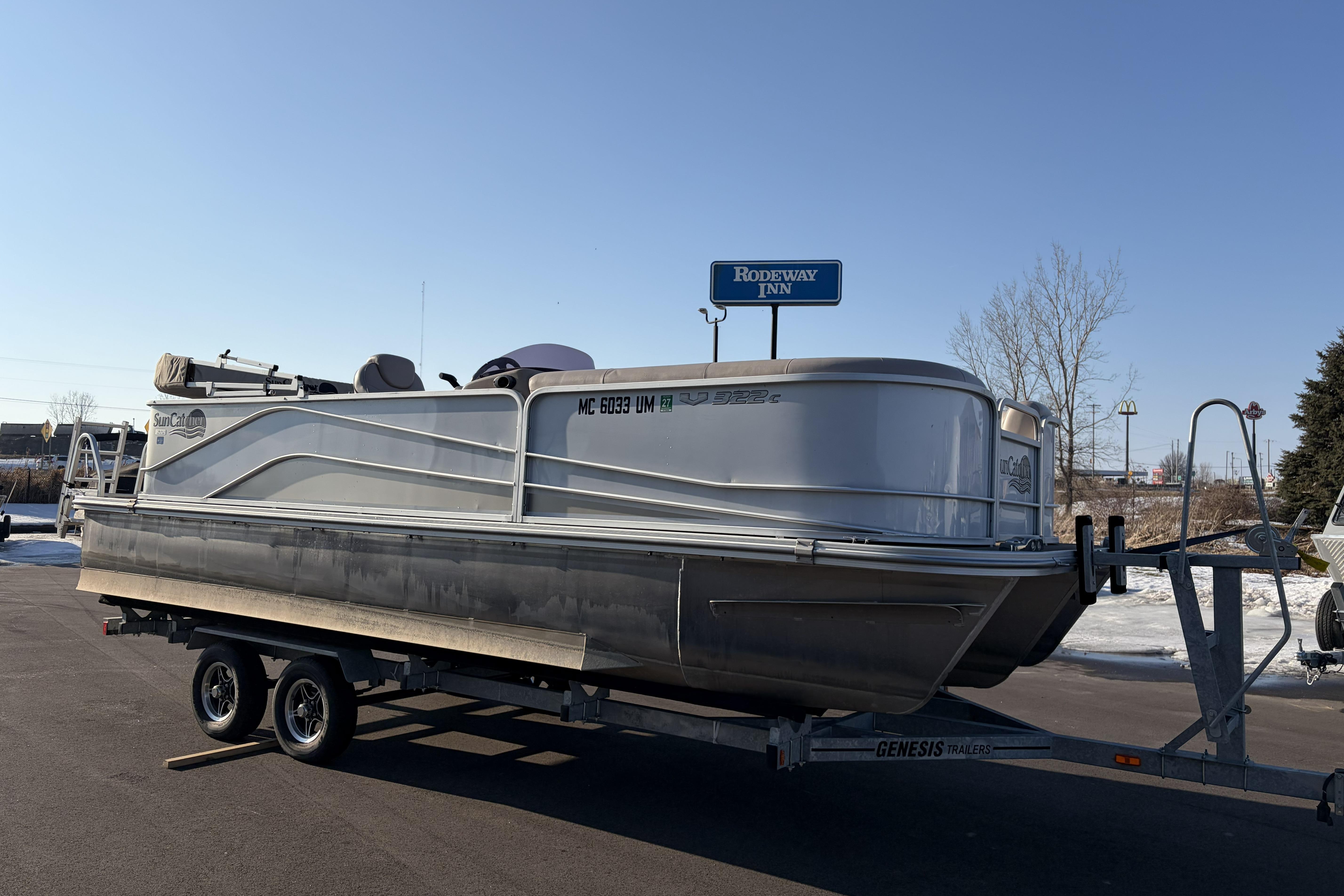 2019 SunCatcher V322 Cruise pontoon boat on trailer, parked near Rodeway Inn.
