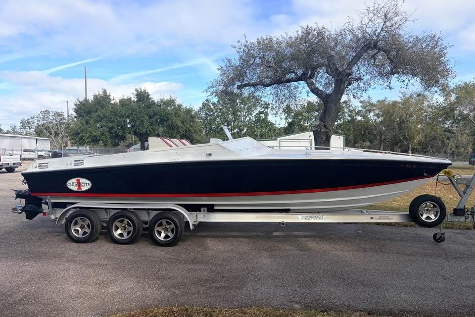 1983 Cigarette 24' Classic speedboat on trailer, parked outdoors.
