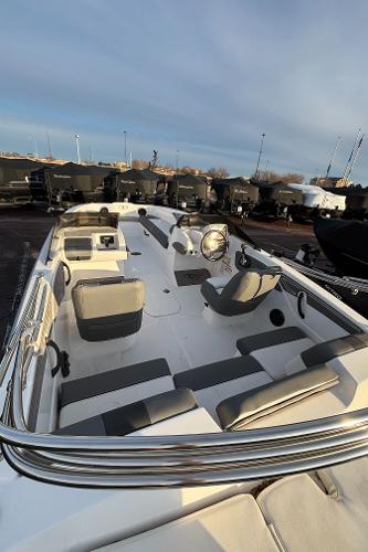 2024 Tahoe T21 boat interior with seating and steering wheel, docked outdoors.