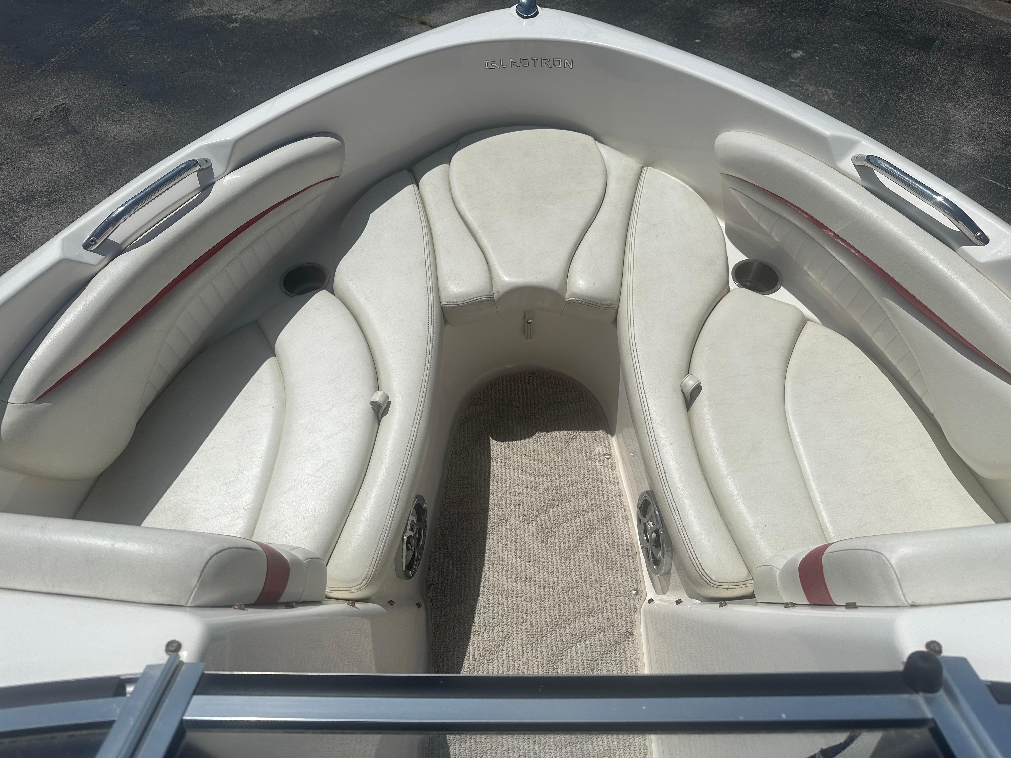 2008 Glastron 205 GX boat interior with white cushioned seating and carpeted floor.