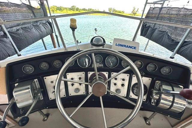 1989 Carver 32 Aft Cabin Motor Yacht helm with steering wheel and navigation instruments.