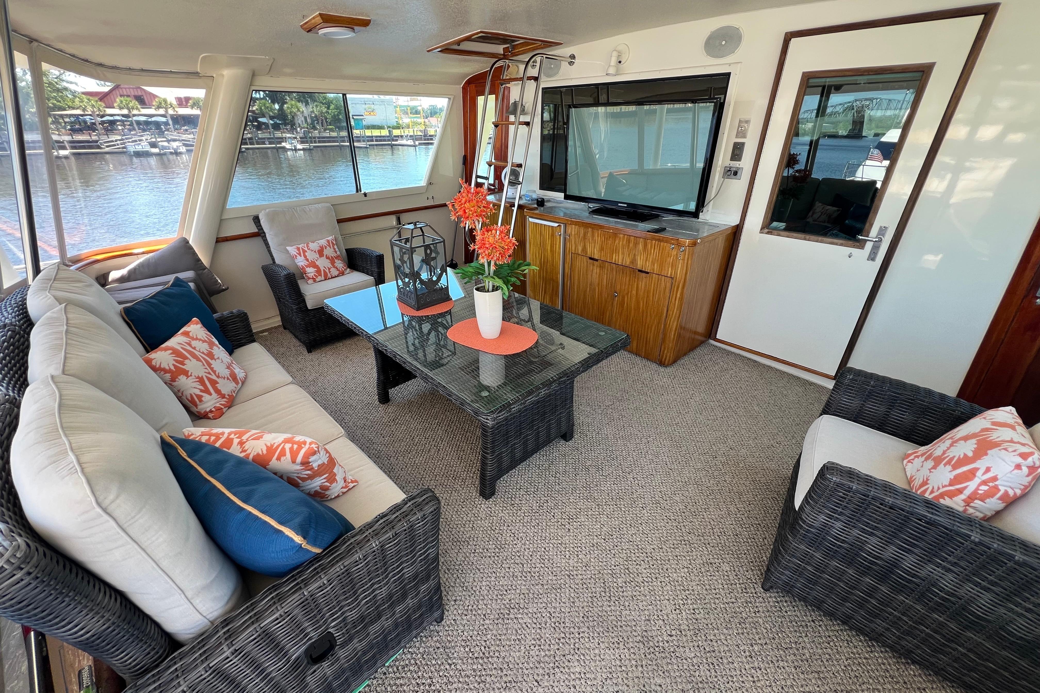 Luxurious 1987 Hatteras 70 Cockpit Motor Yacht interior with elegant seating and waterfront view.