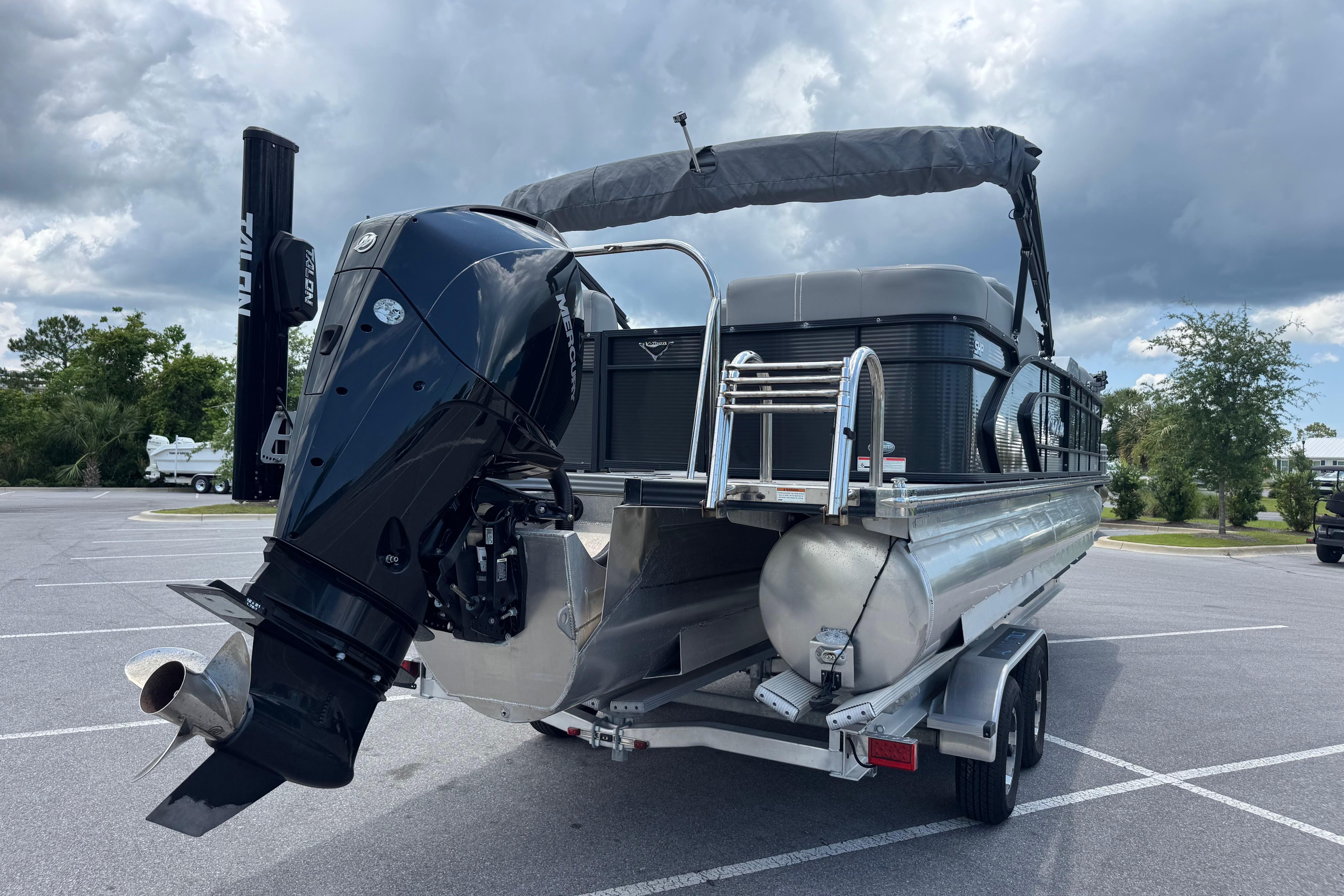 2022 Manitou 25 Encore pontoon boat with powerful outboard motor on trailer.