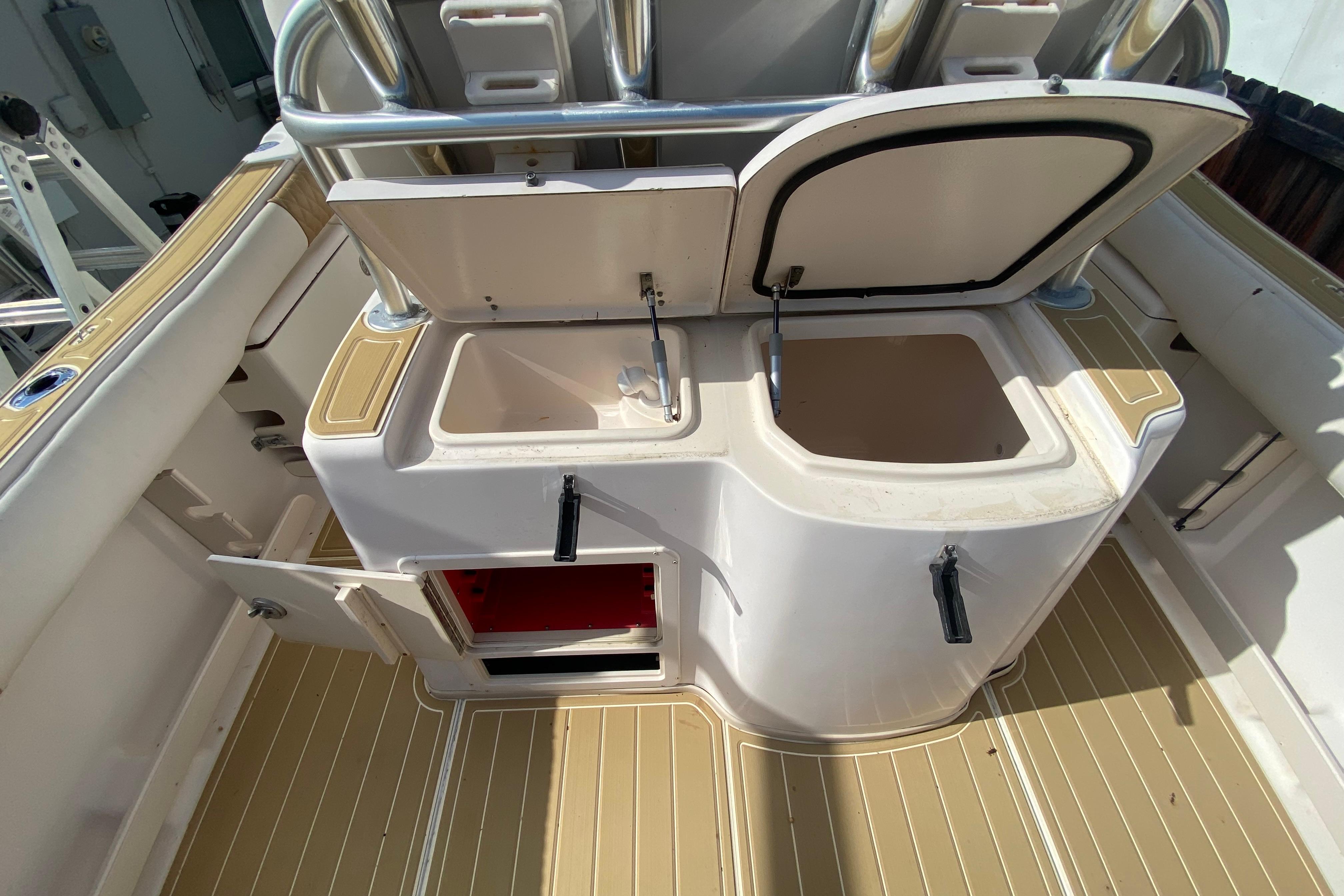 2004 Grady-White Canyon 283 boat interior with open storage compartments and sink.