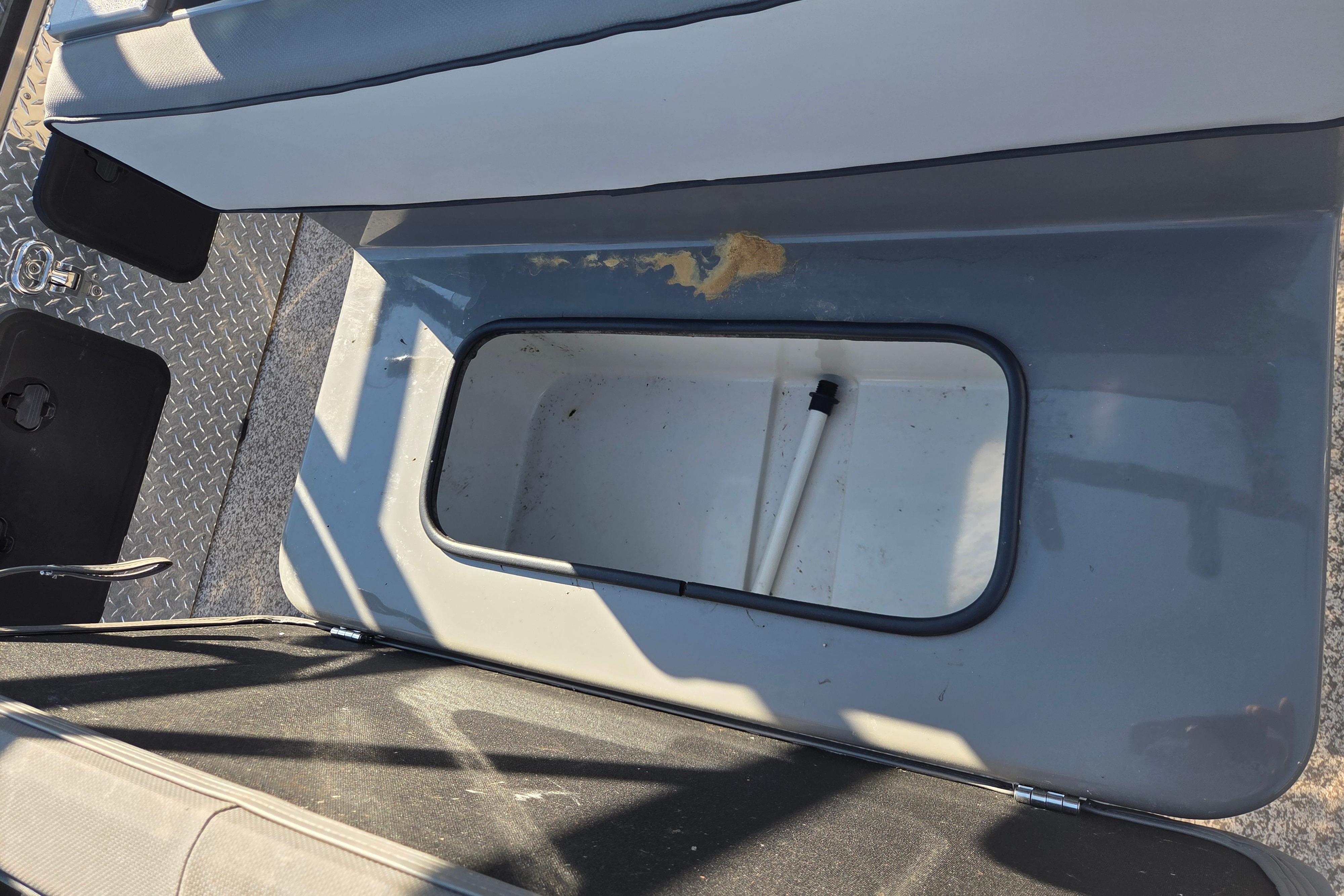 2024 Angler Qwest 8526 Pro Troll boat storage compartment with open lid.
