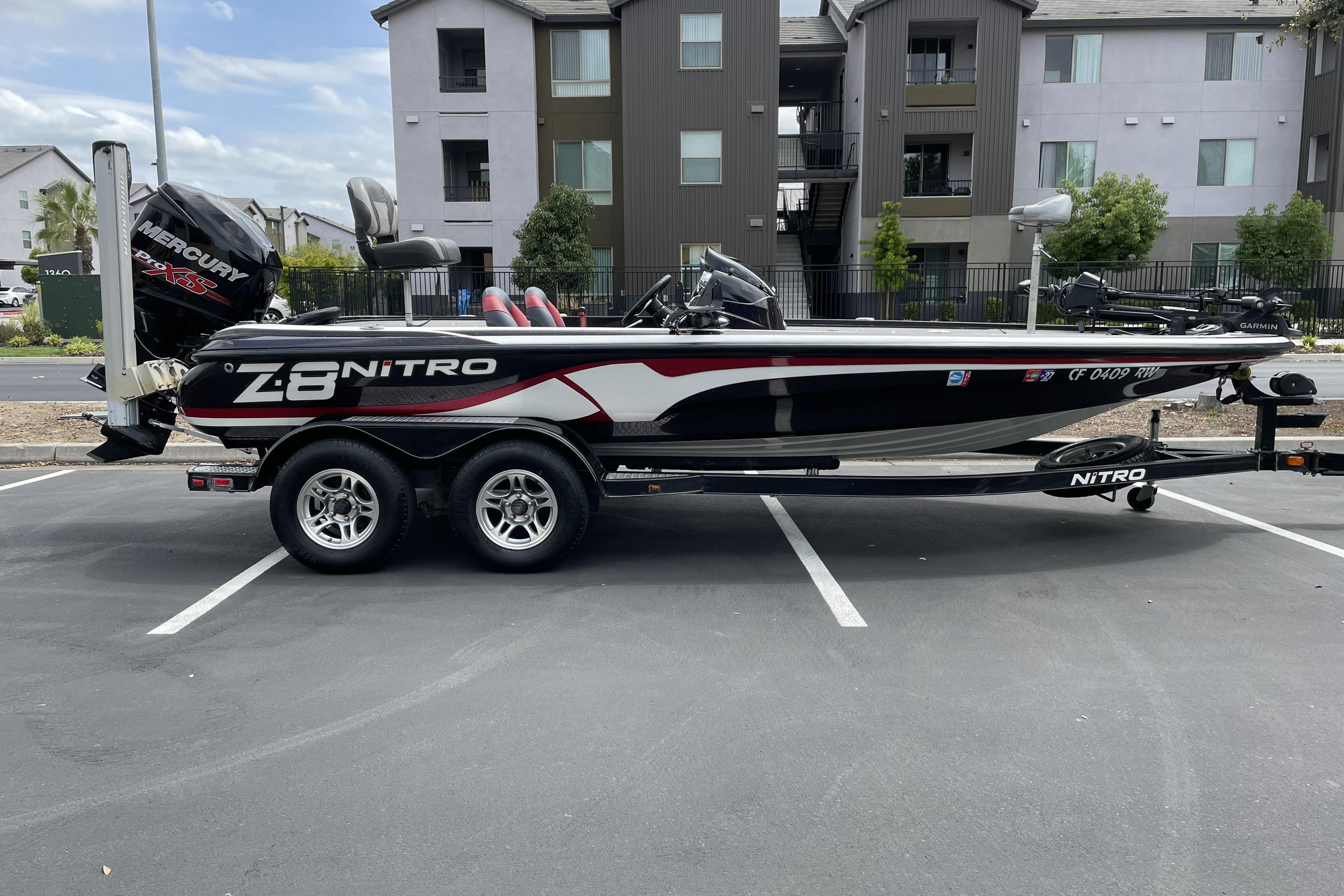 2013 Nitro Z-8 boat with Mercury engine on trailer in parking lot.