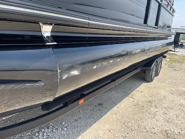 2023 Regency 250 LE3 pontoon boat on a trailer, side view.