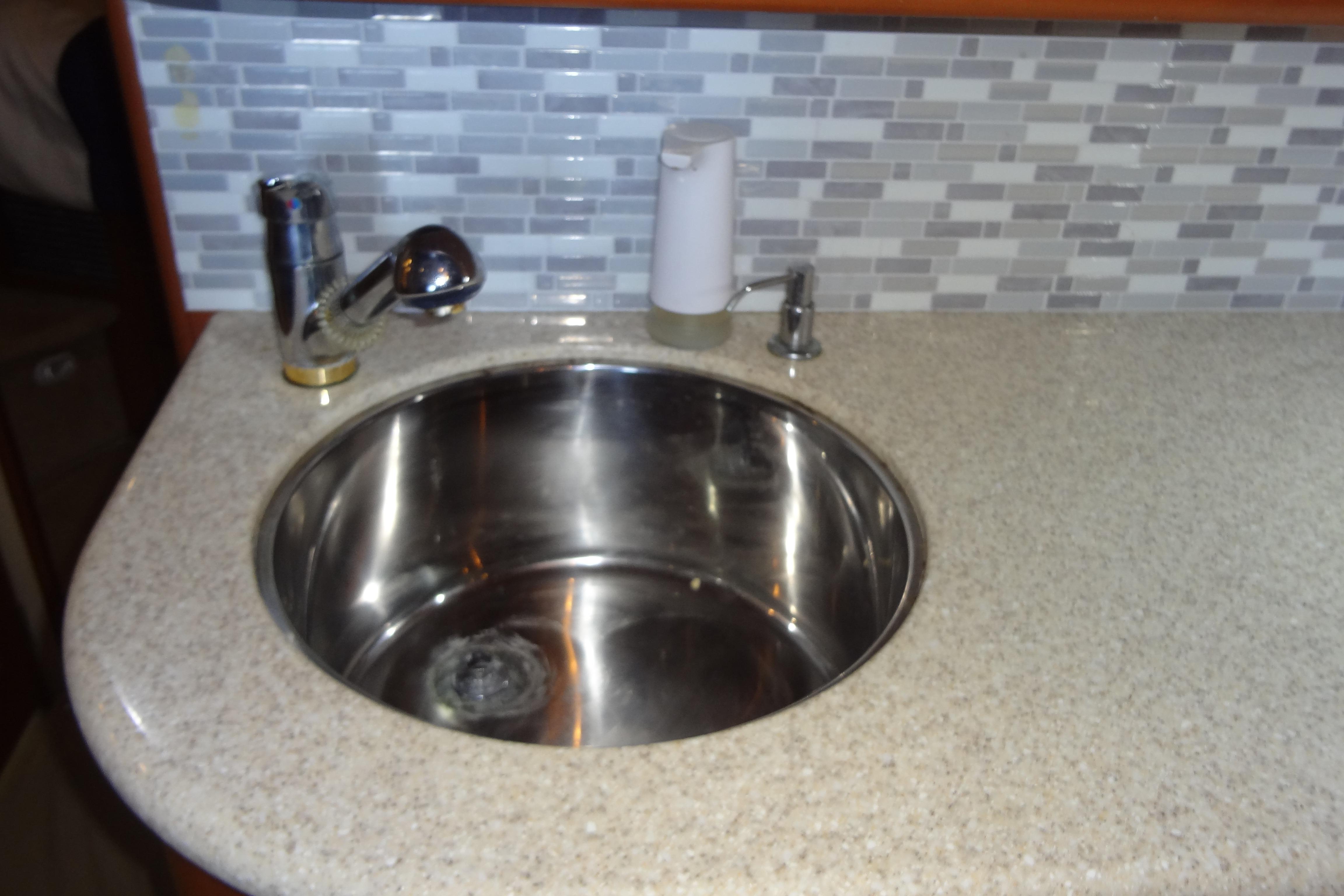 Stainless steel sink in 2005 Silverton 34 Convertible yacht kitchen with tiled backsplash.