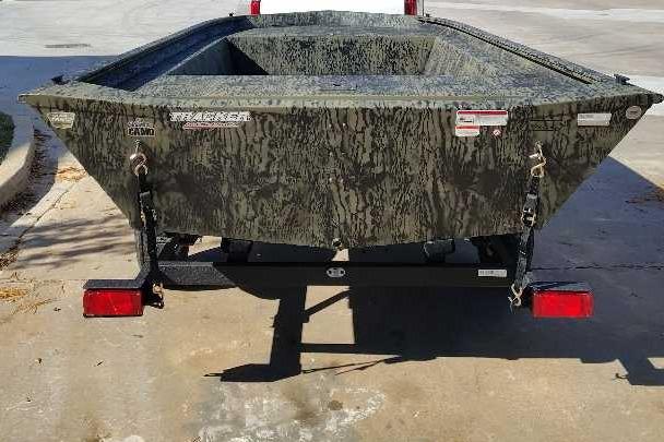 2026 Tracker Grizzly 1754 Utility boat on trailer, camo design, rear view.