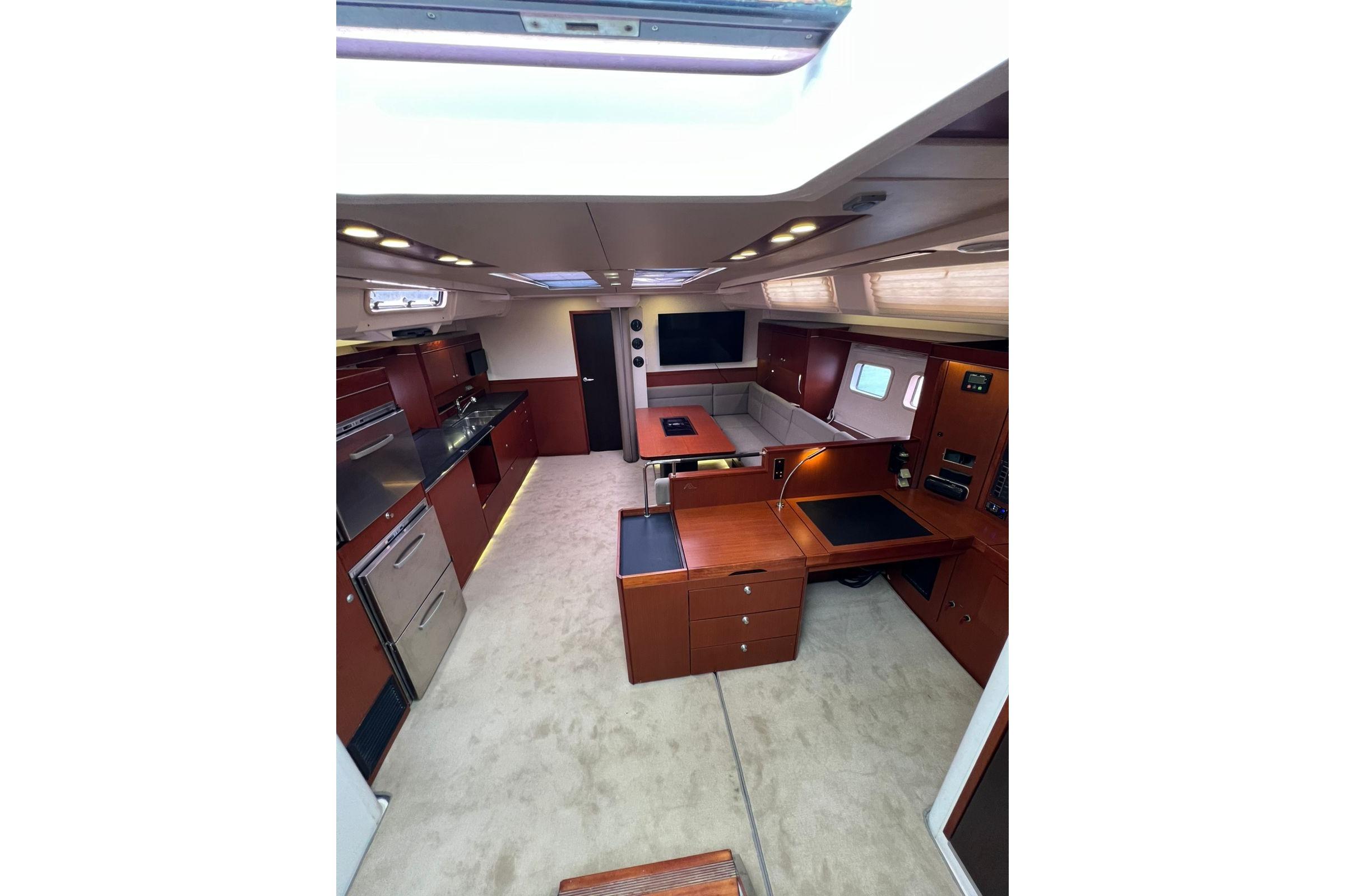 Luxurious interior of 2013 Hanse 575 yacht with modern kitchen and seating area.