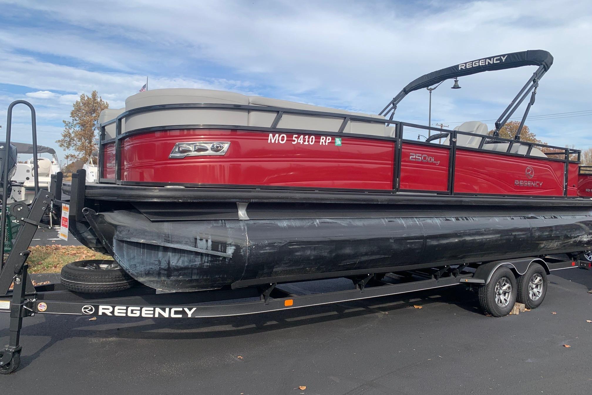 2024 Regency 250DL3 pontoon boat on trailer, red exterior, parked outdoors.