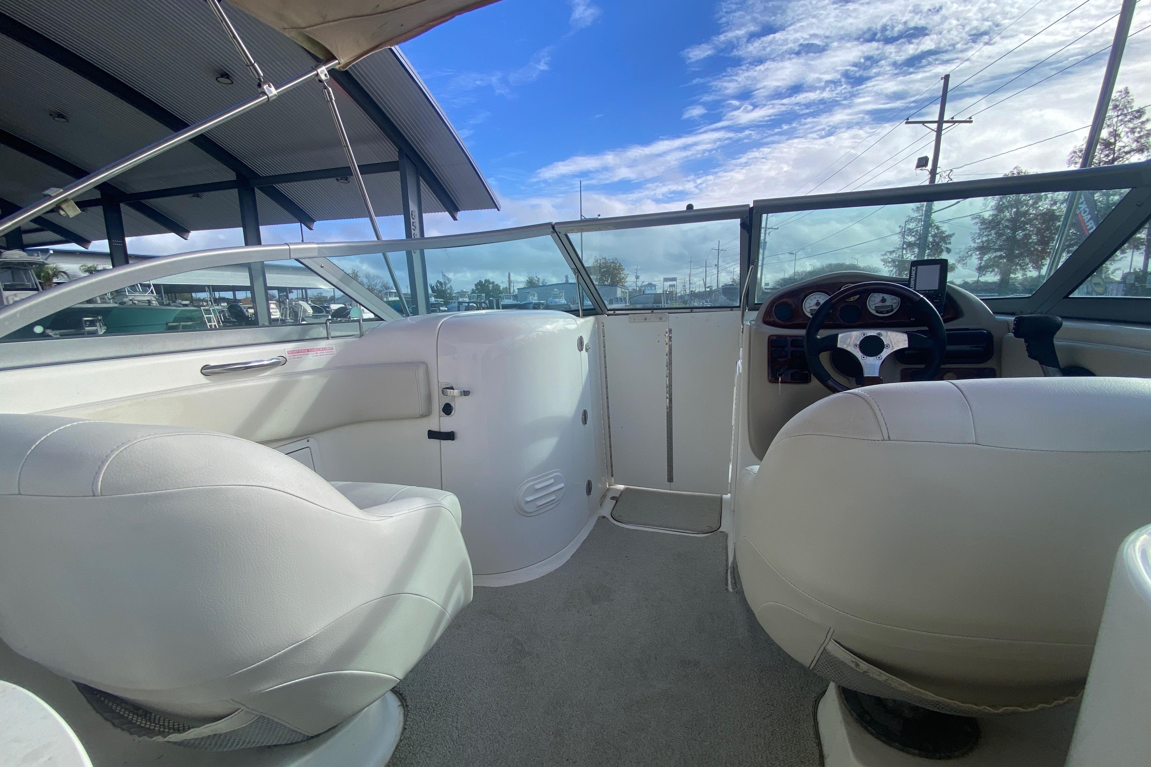 2007 NauticStar 230DC Sport Deck interior with white seating and steering console.
