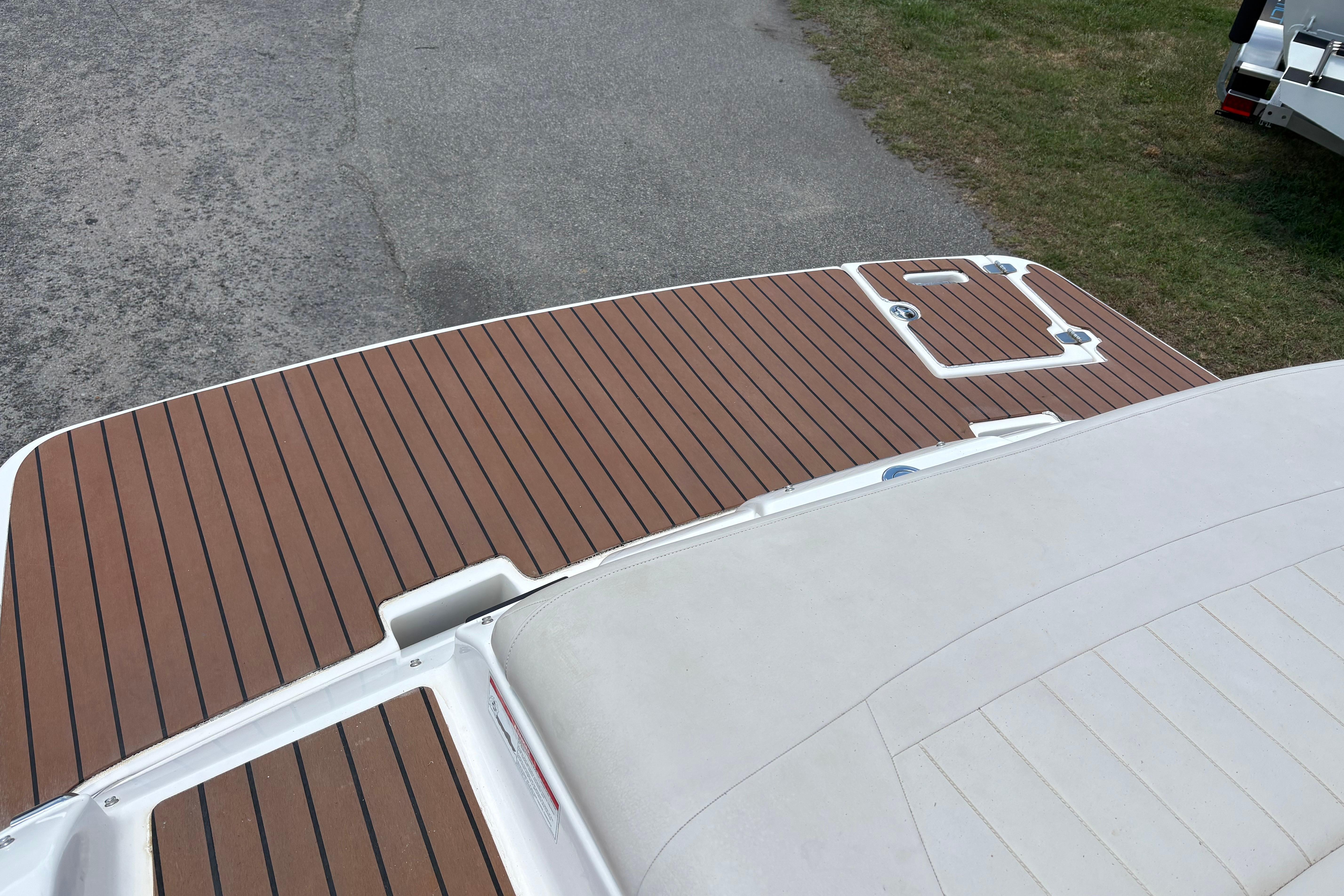 2008 Regal 1900 Bowrider boat deck with brown wood finish, parked on pavement.