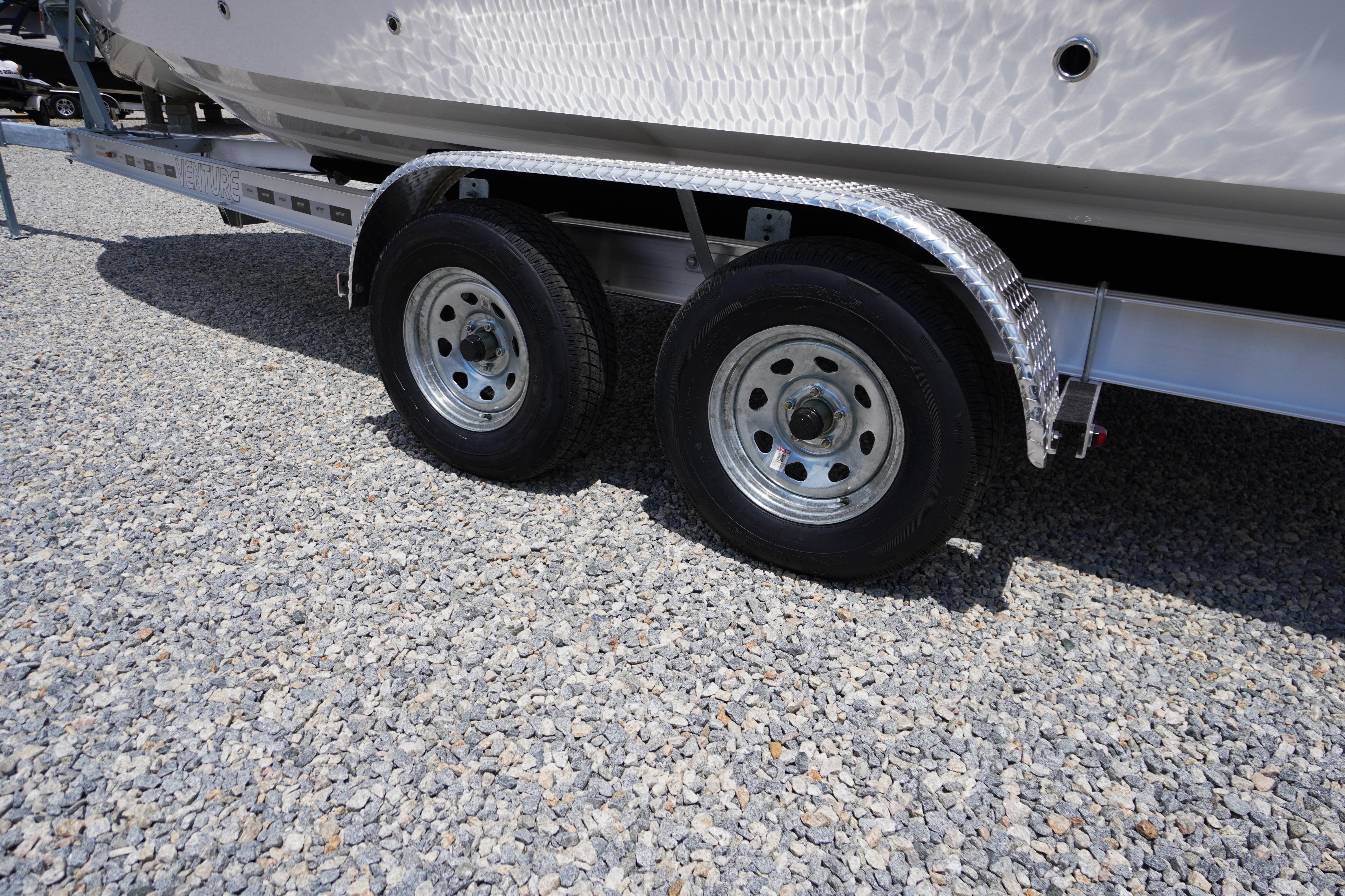 Trailer wheels of a 2026 Chaparral SSX 4 boat on gravel surface.