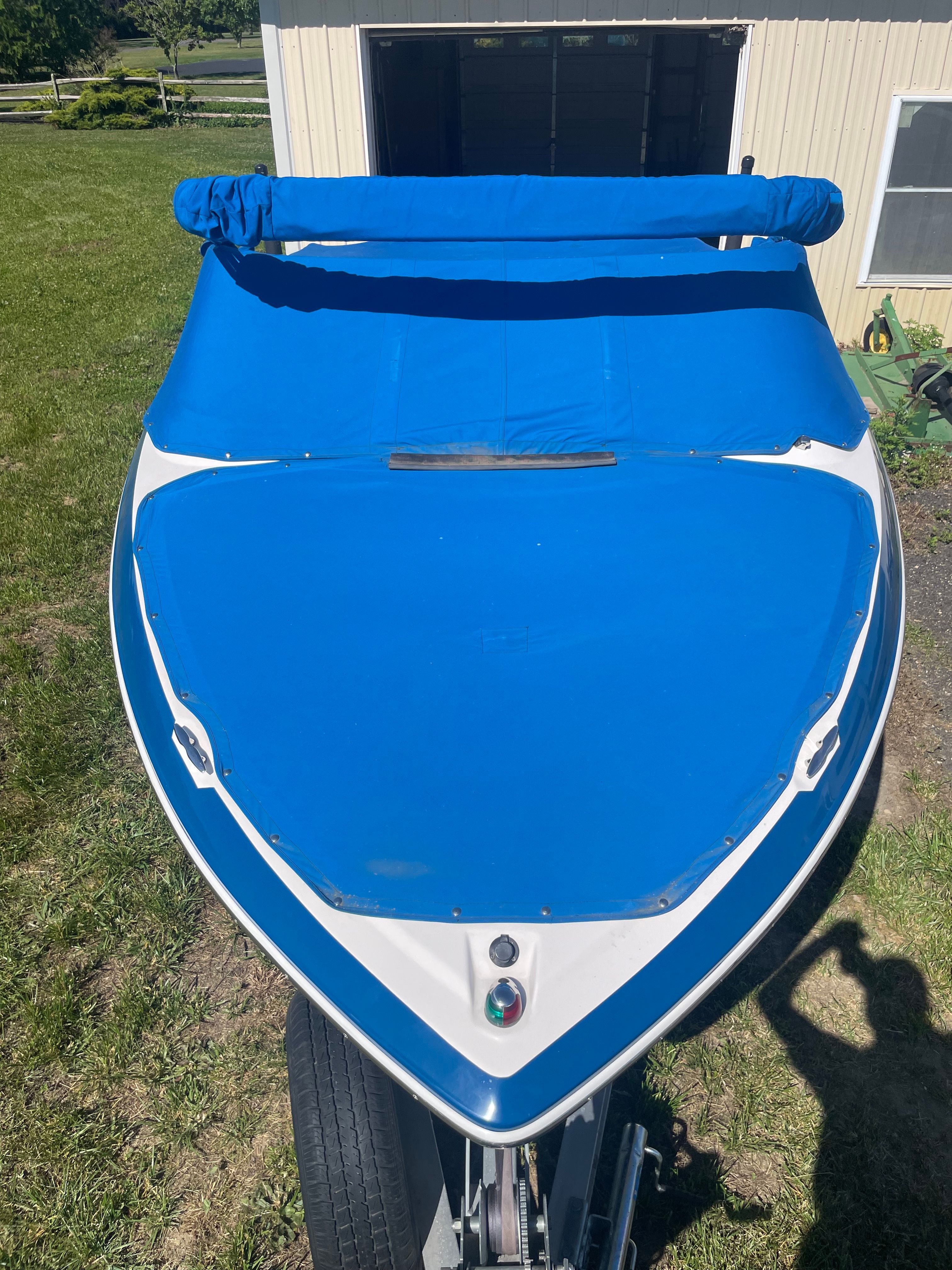 A 2016 Regal 1900 ESX Bowrider with a blue cover, parked on a trailer.