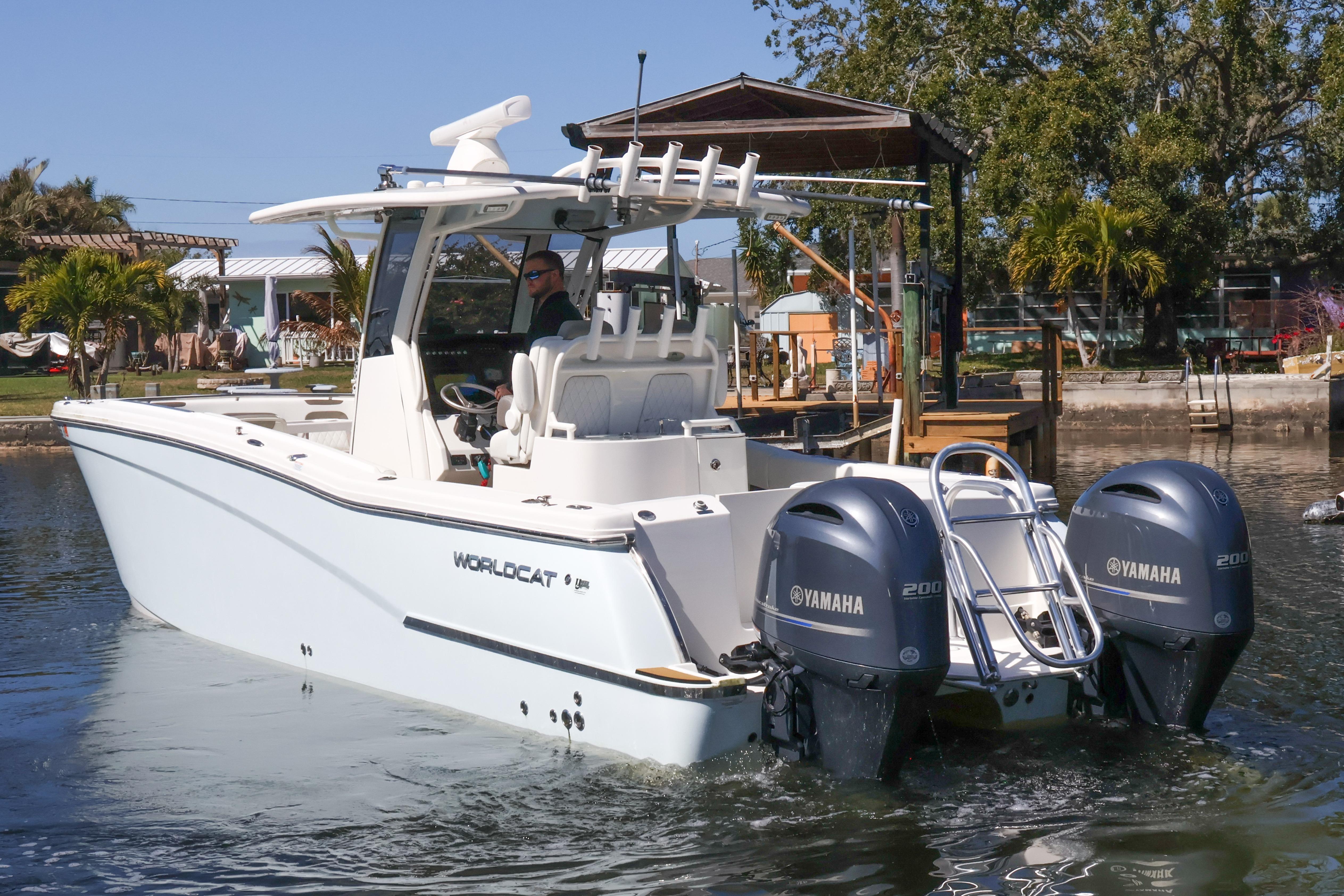 2022 World Cat 280 CC-X boat with dual Yamaha engines on a calm waterway.